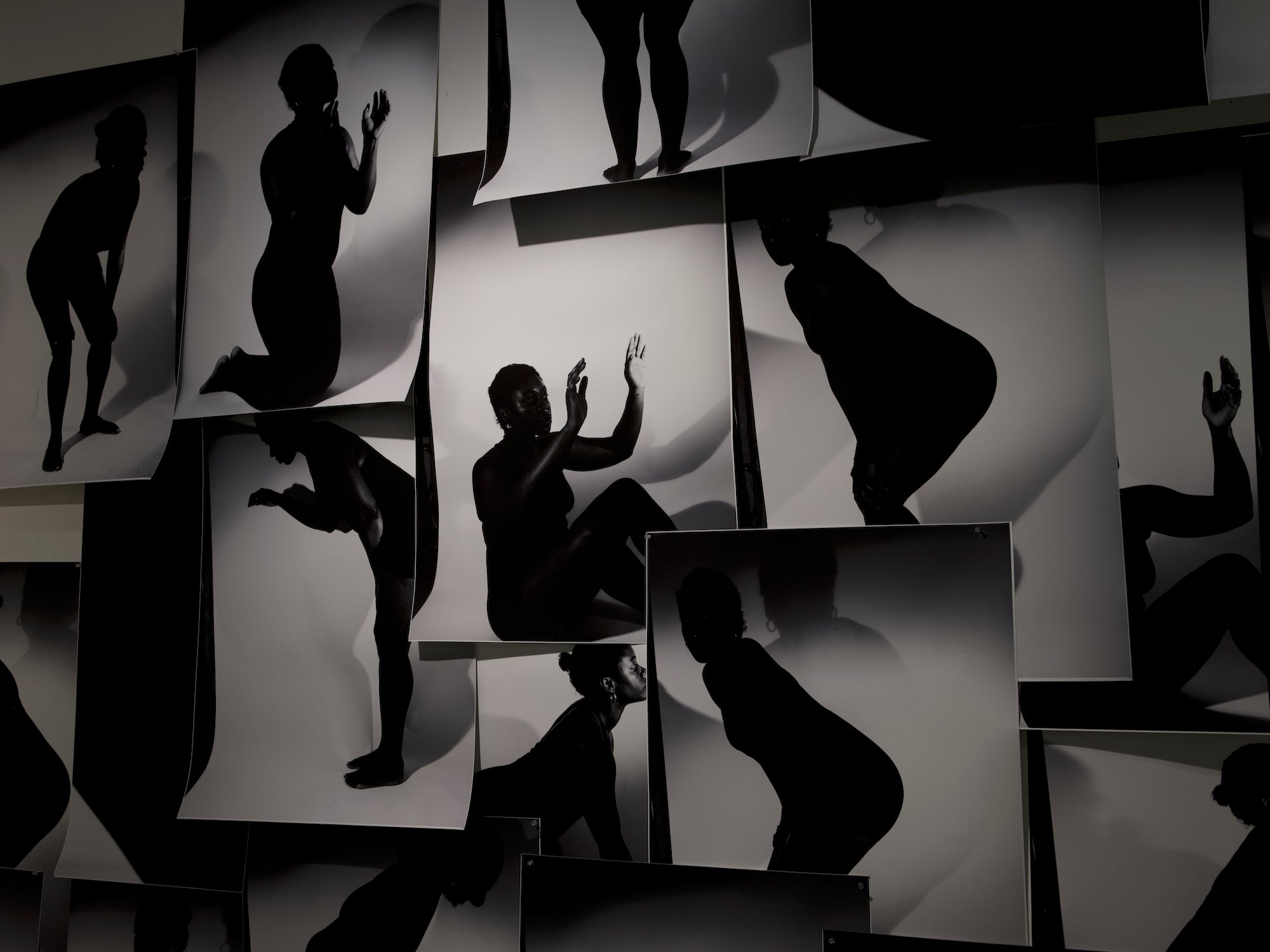 a massive collage on a wall with black and white silhouette images