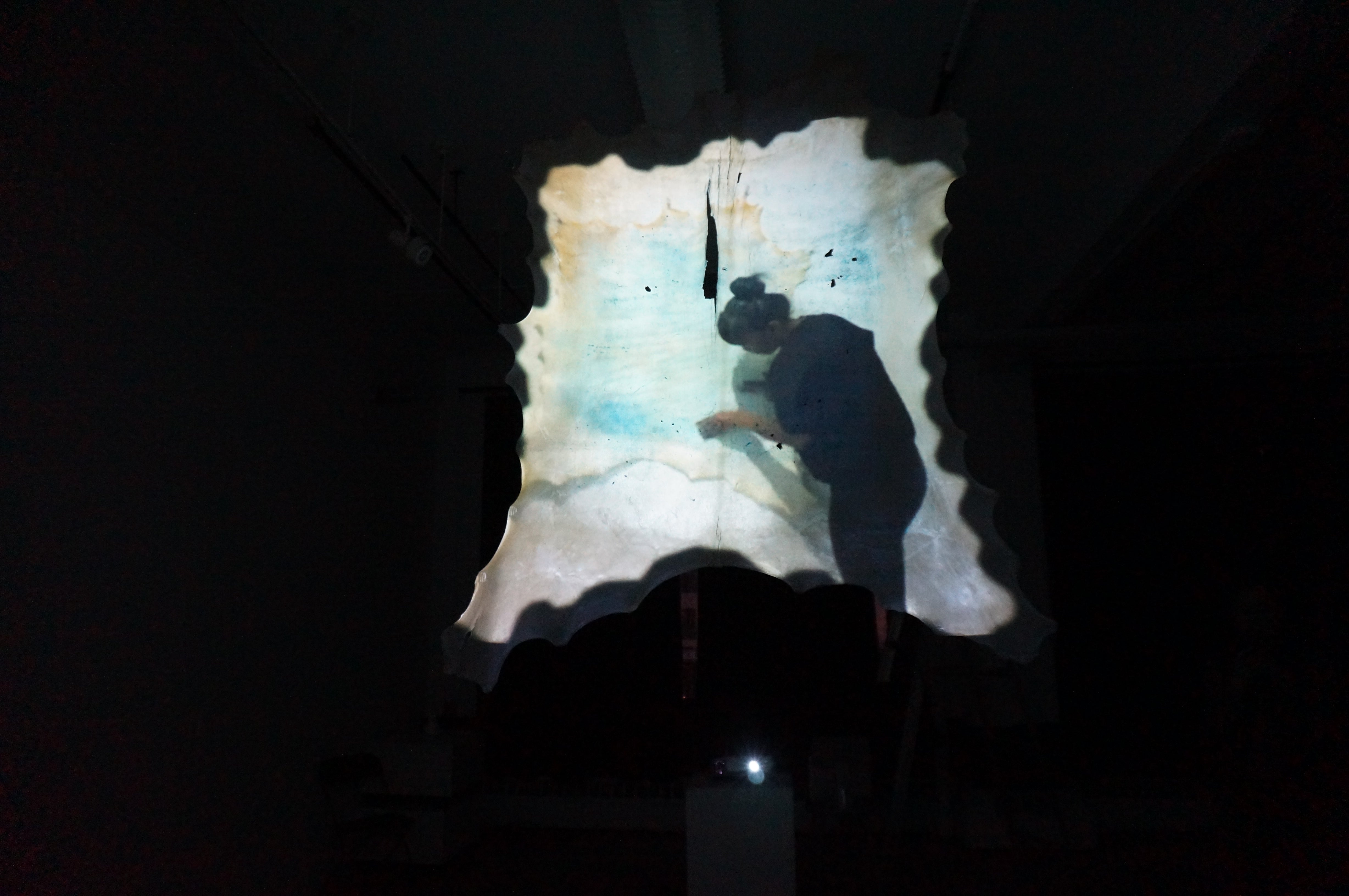 Still of the video projecting on the parchment in the museum setting 