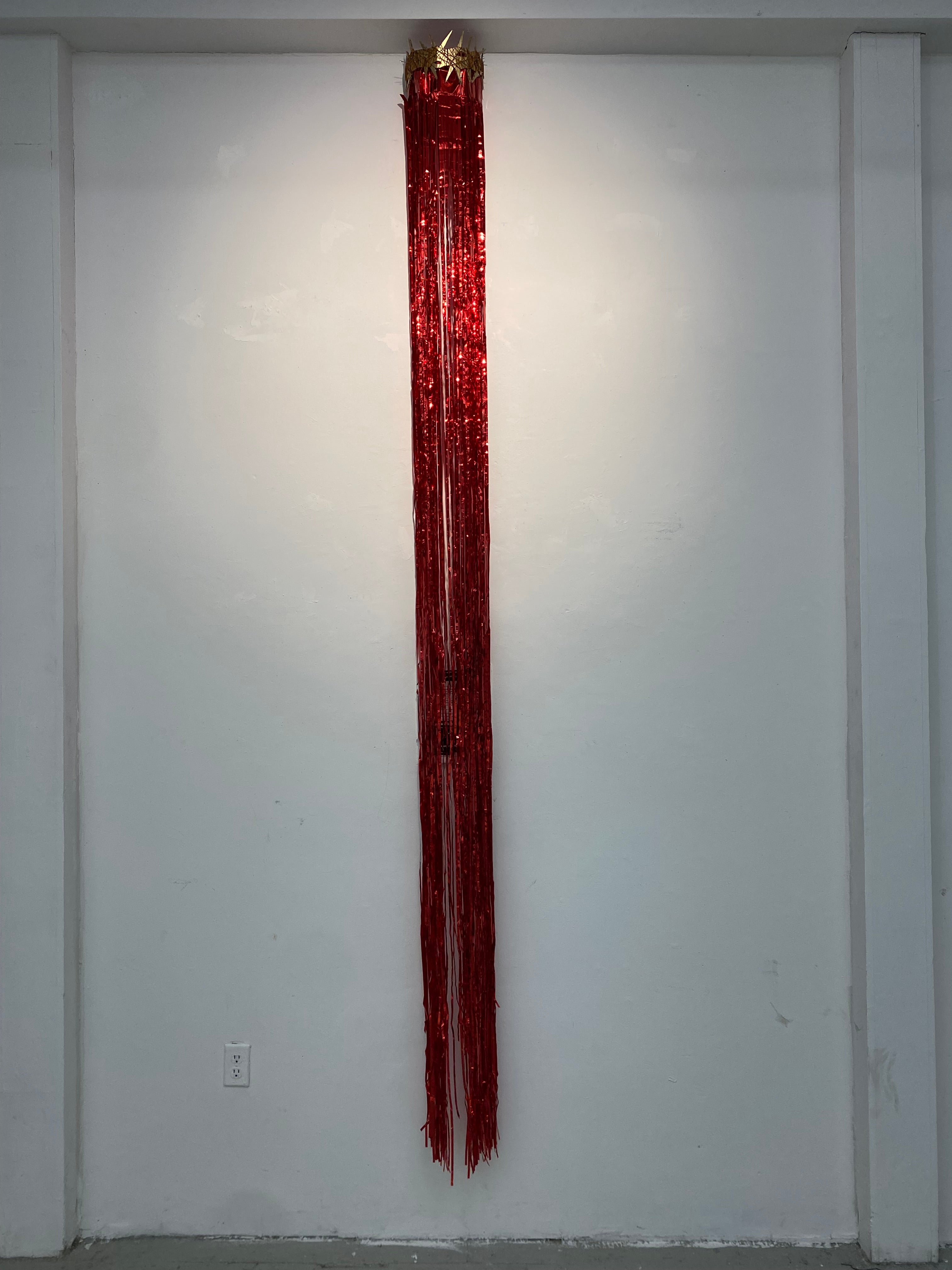 cardboard crown with red streamer hang off of it covering a document.