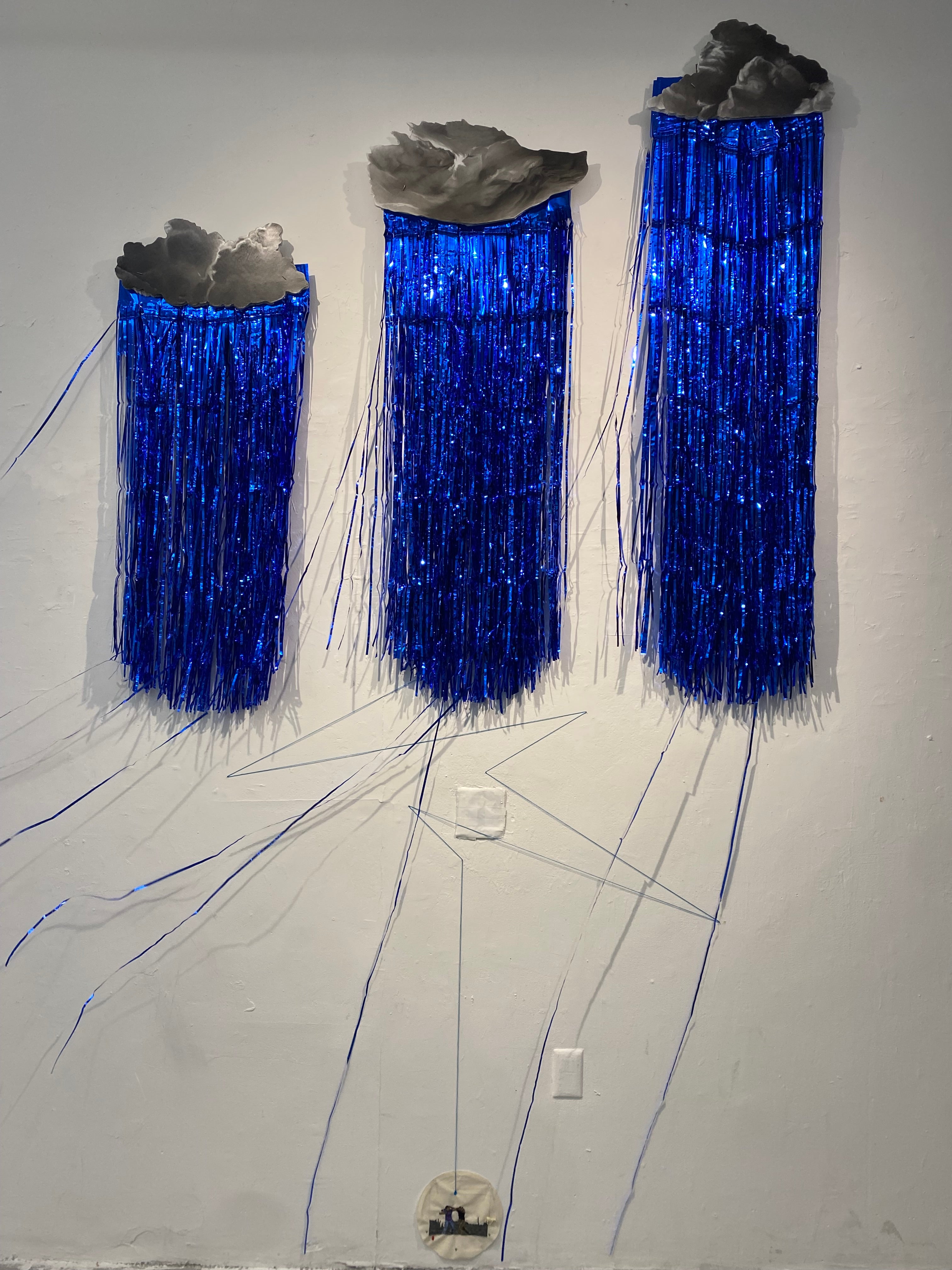 clouds and blue streamers raining over a small image of two figures fighting.