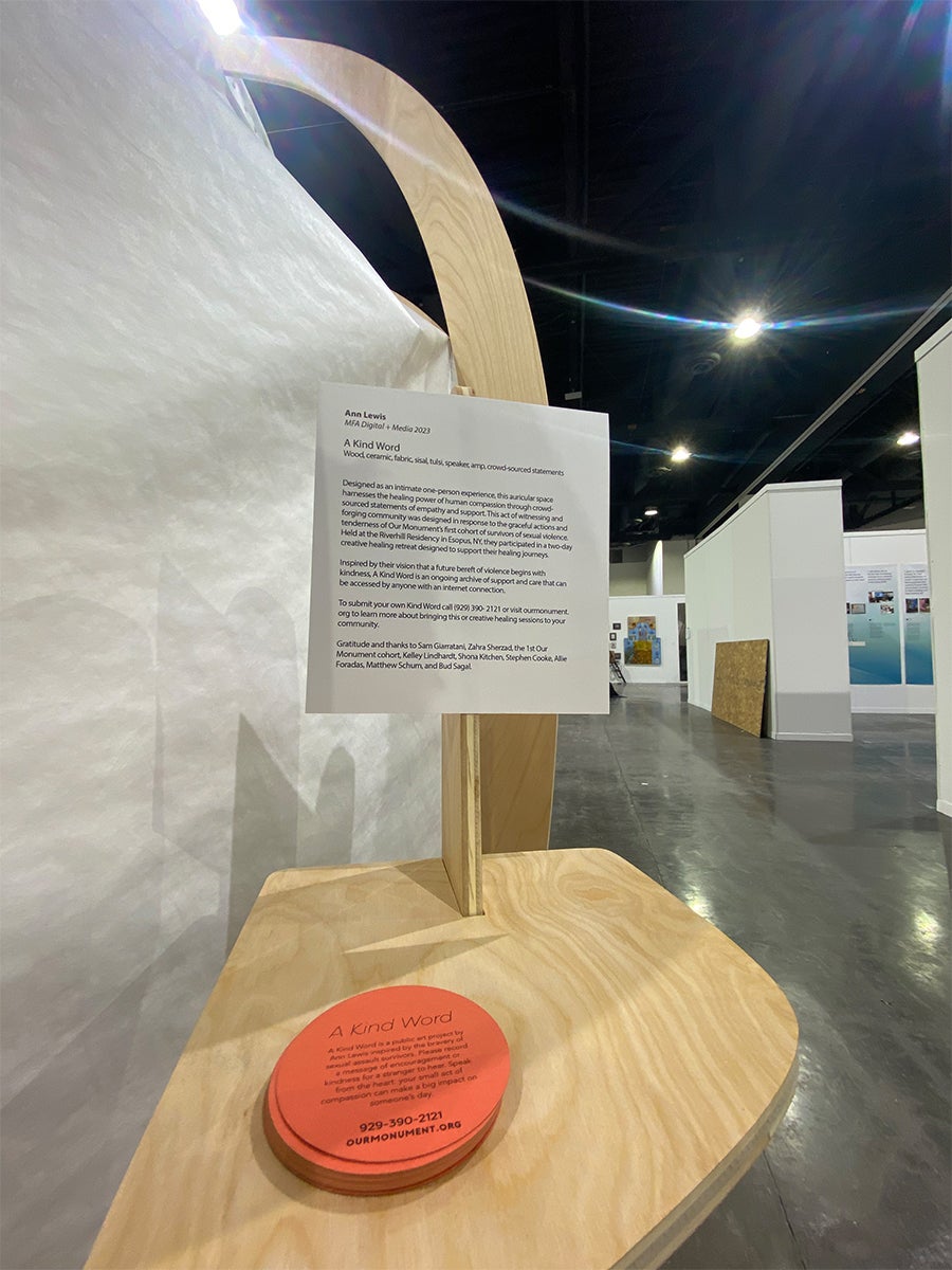 A wooden stand holds orange and white cards explaining the monument