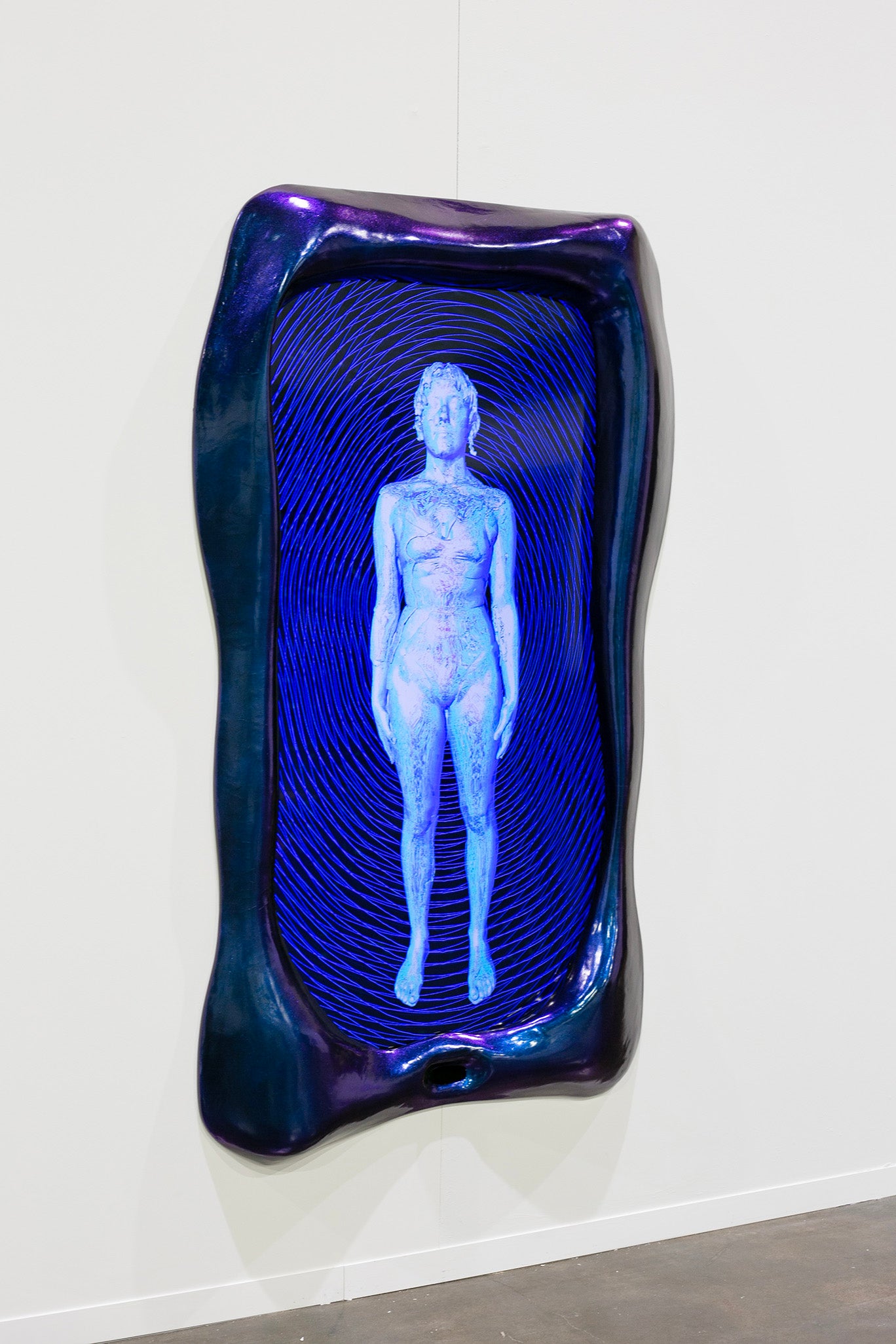 A blue and purple frame surrounds a screen showing a cyborg like figure