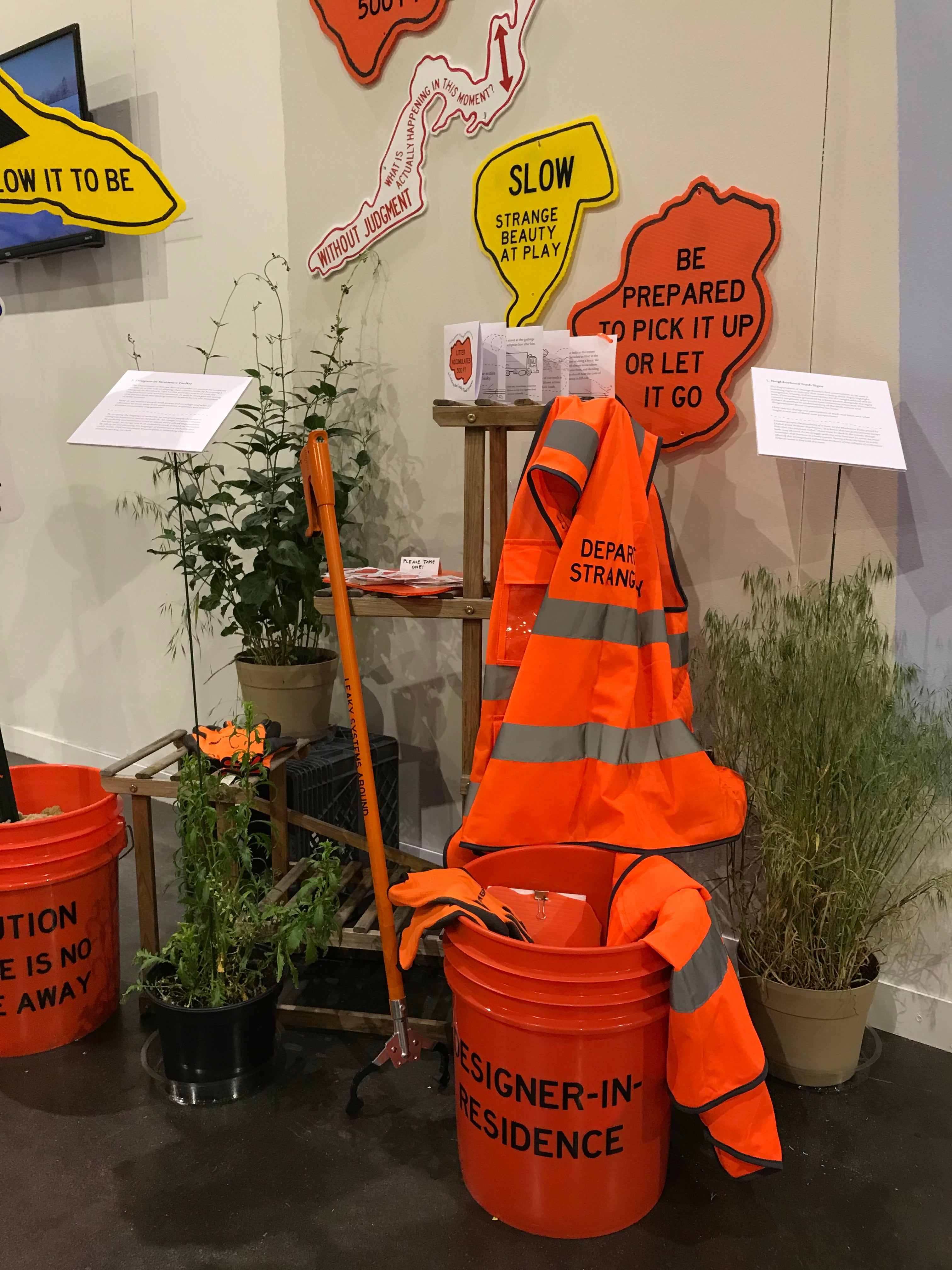 Installation view of a Designer-in-Residence Toolkit, including bucket, trash grabber, vest, pamphlet, clipboard, stickers, and gloves