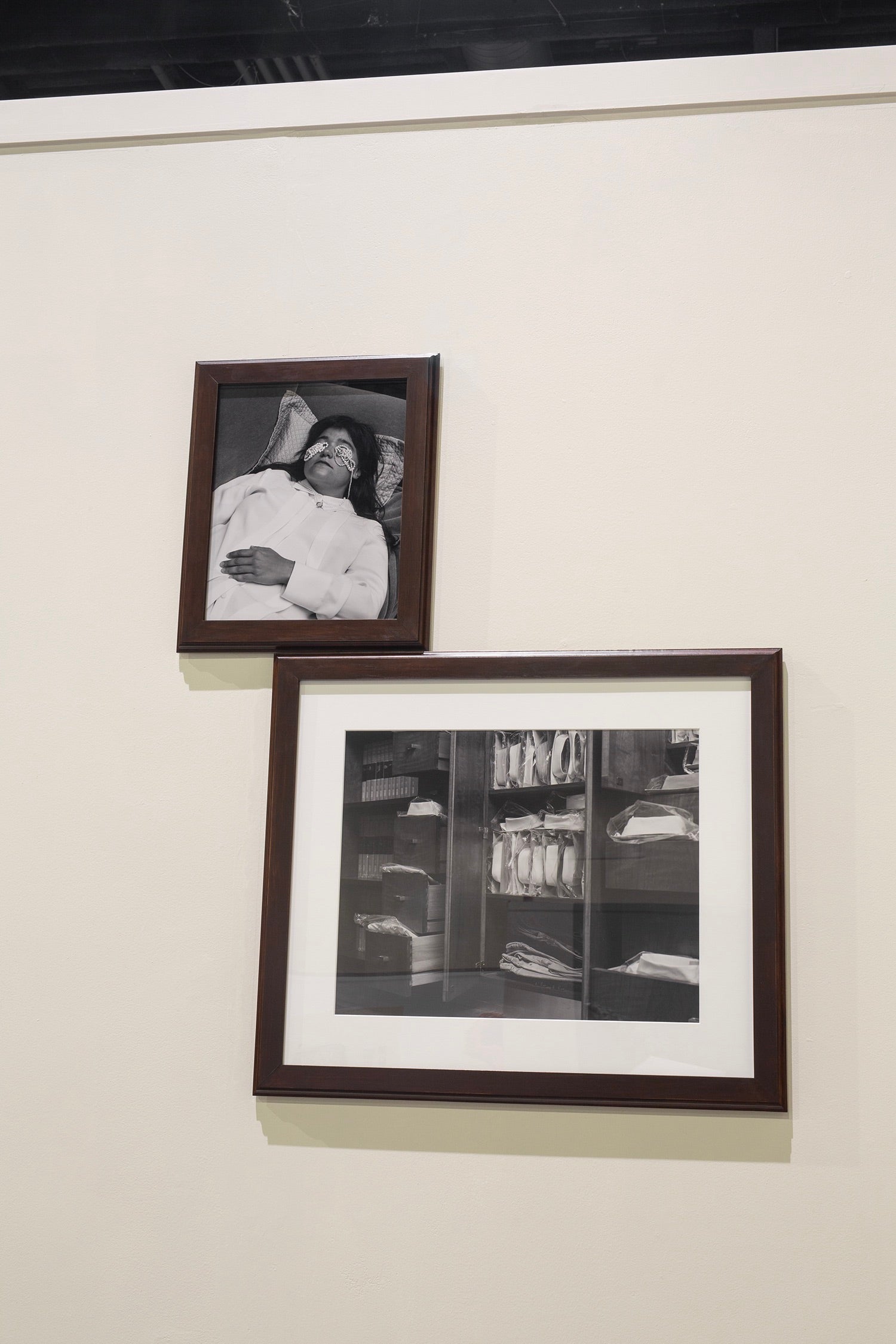 Color pigment print of a suitcase of busts mounted and bisected in a wall corner