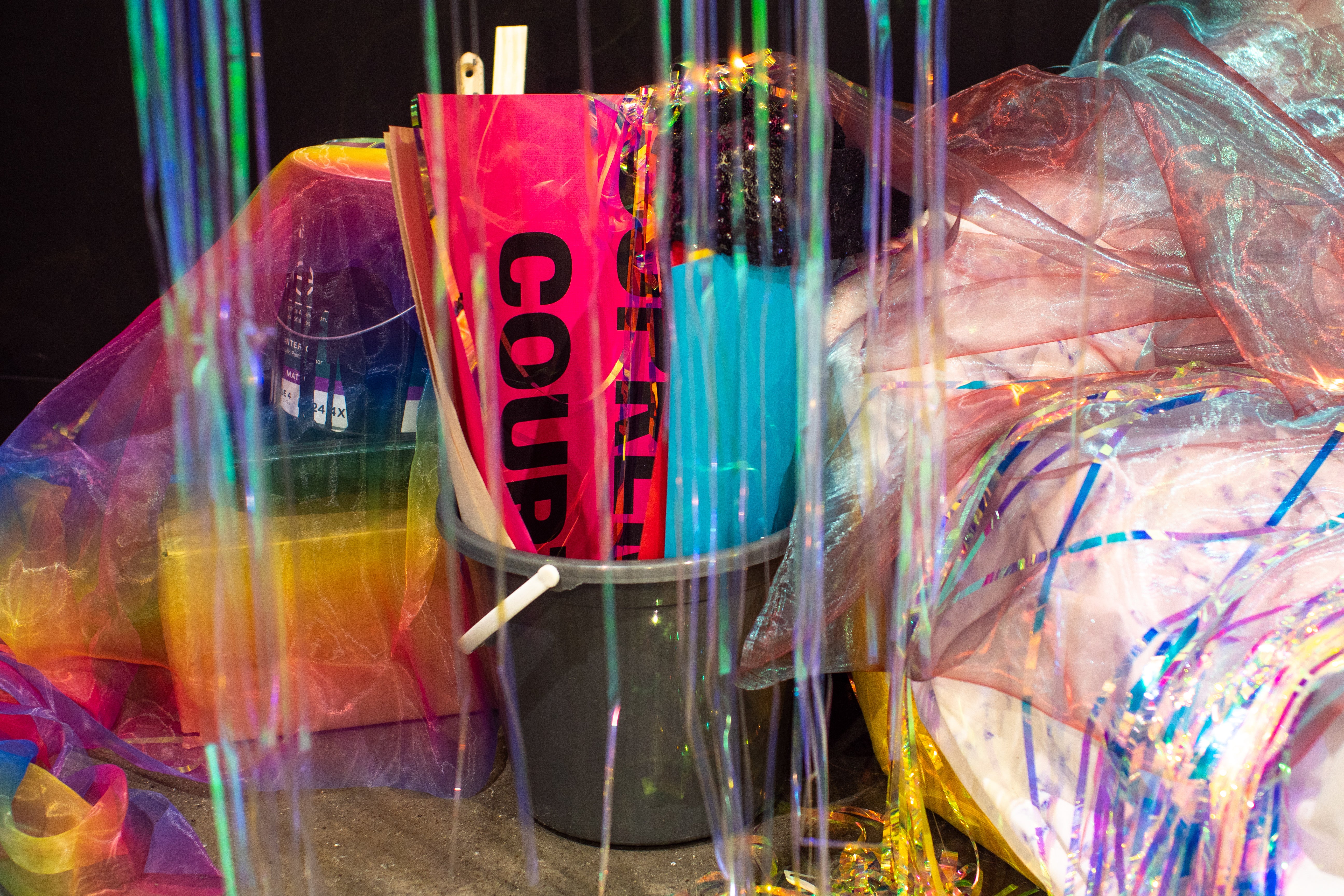 tiridescent sheer Fuschia with blue organza, iridescent vinyl party streamers, photo documents and Instagram stories printed on paper, artist tapes, 'Cruising Utopia' by José Esteban Muñoz 'All About Love: New Visions' by bell hooks, and wooden board.