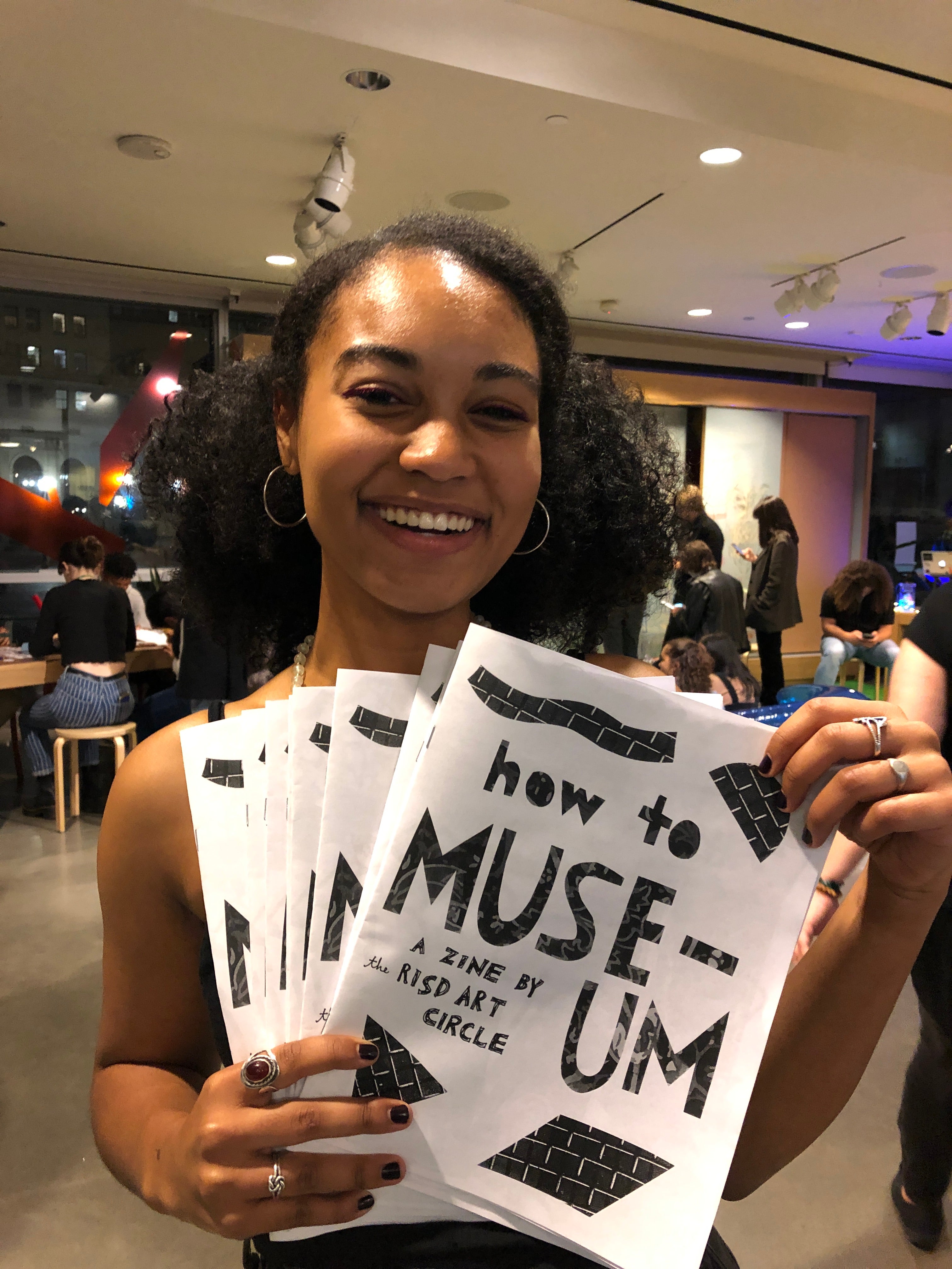 Teenager holding zines about the museum design by RAC