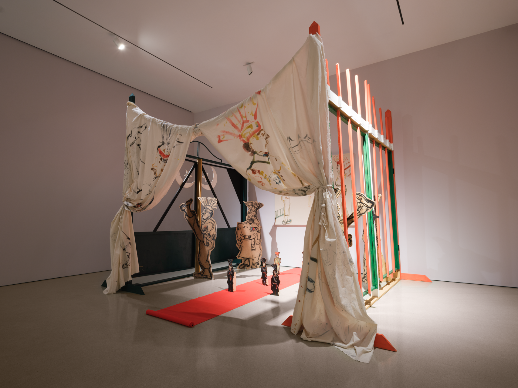 installation comprising oil painting on canvas, masonite, and muslin; charcoal and found fabric on wood cutouts, wooden handmade gates, sound, video performance (05:22), projection, carpet, and hardware
