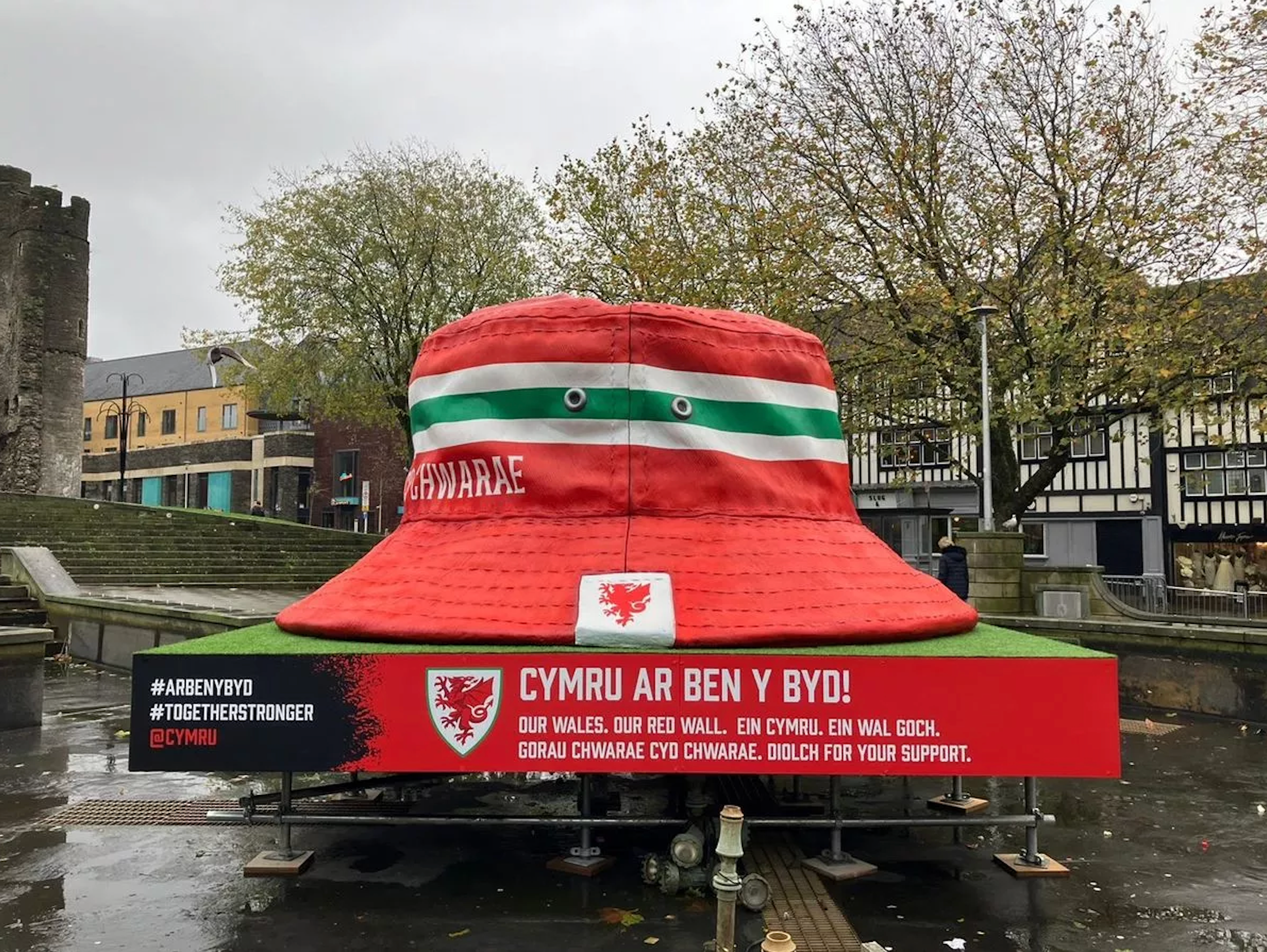 A giant red and green bucket hat sculpture in Swansea's city center.