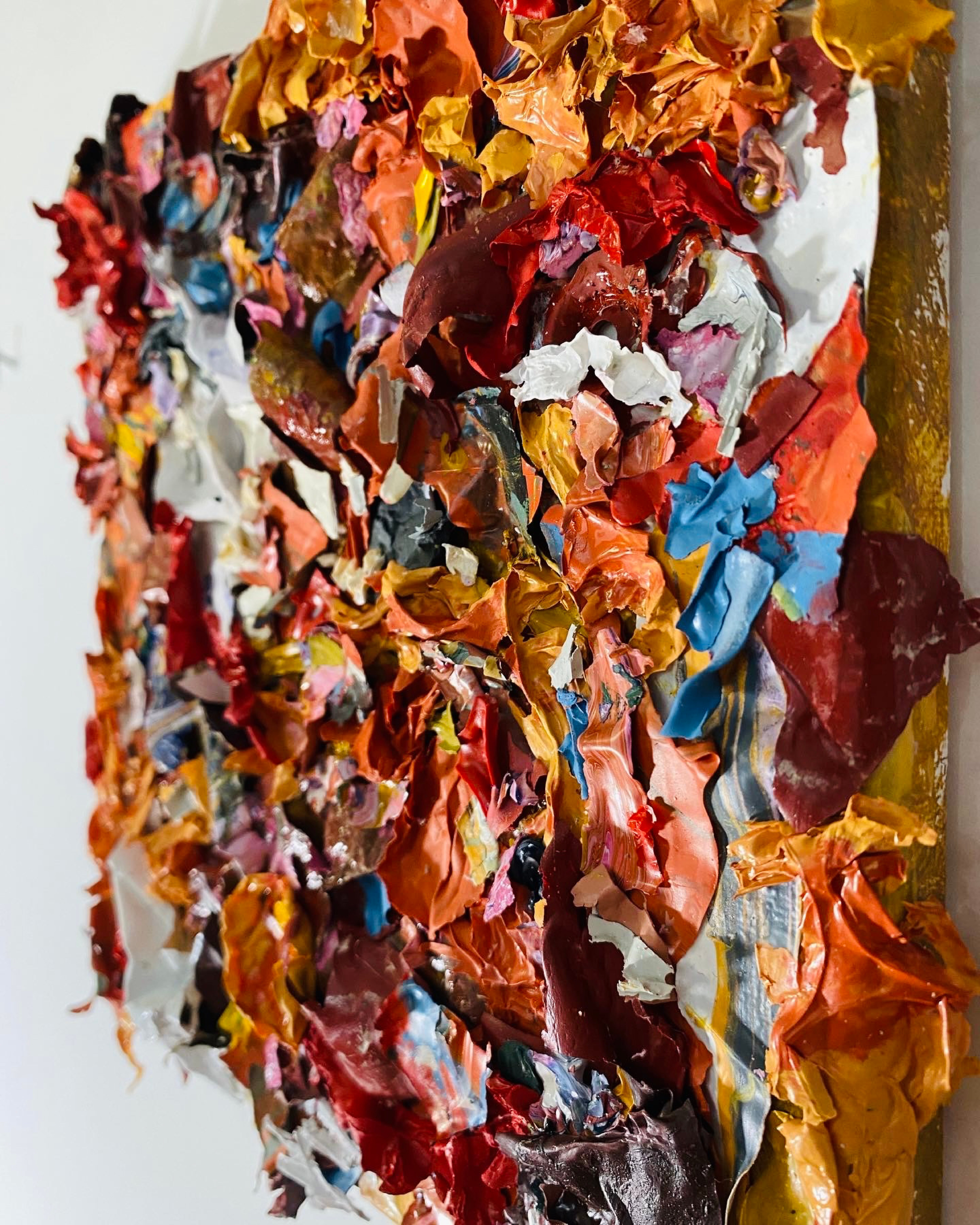 /Small%20pieces%20of%20scrap%20paint%20are%20glued%20onto%20a%20canvas.%20The%20pieces%20vary%20but%20are%20roughly%201%22x1%22.%20The%20scrap%20colors%20are%20red%2C%20yellow%2C%20blue%2C%20orange%20and%20white.
