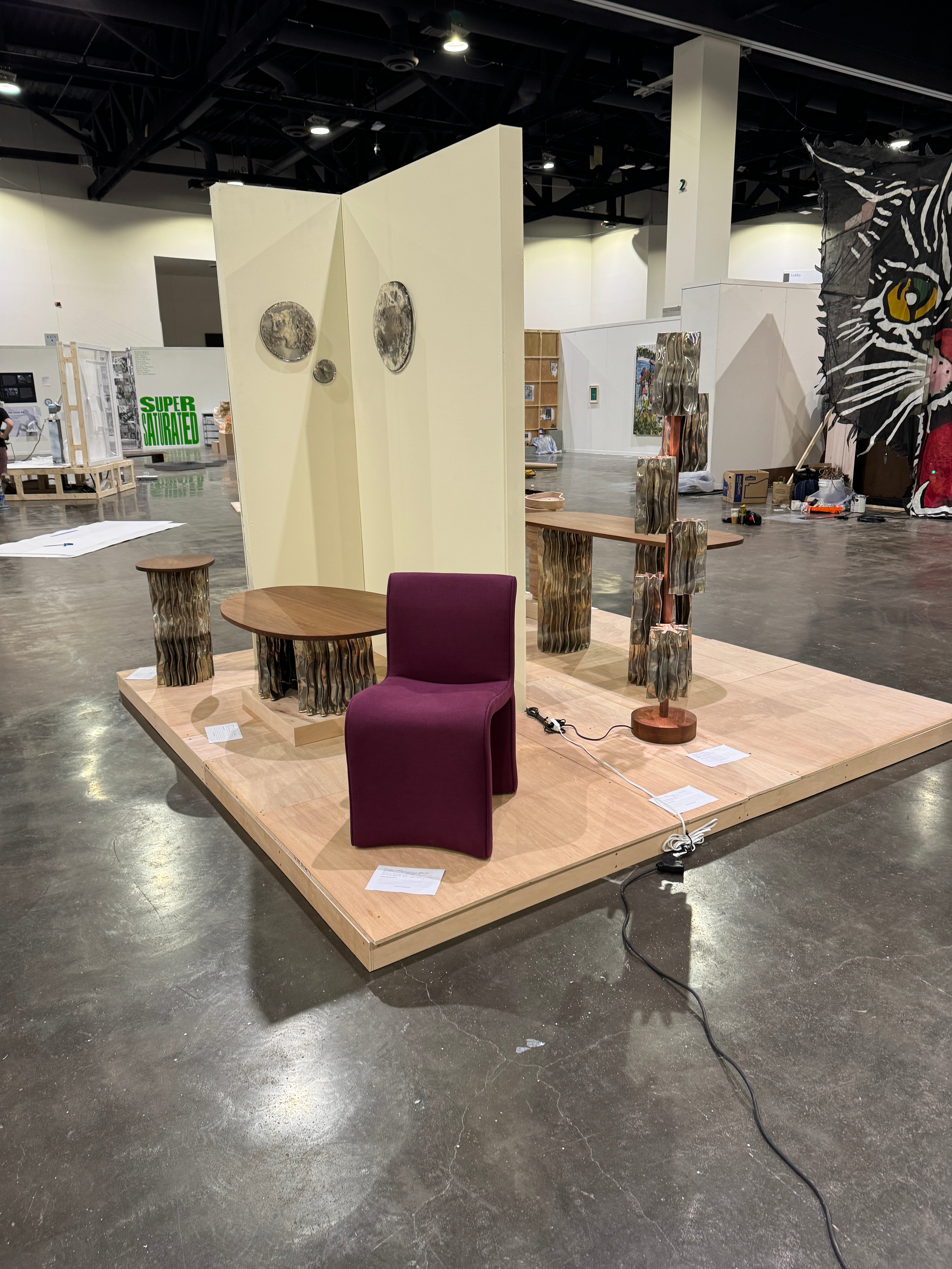 A modern furniture collection includes a coffee table, console table, pedestal table, and two floor lamps. The tables have an aluminum base and walnut tops. The floor lamps display decorative aluminum shades and central walnut stands.