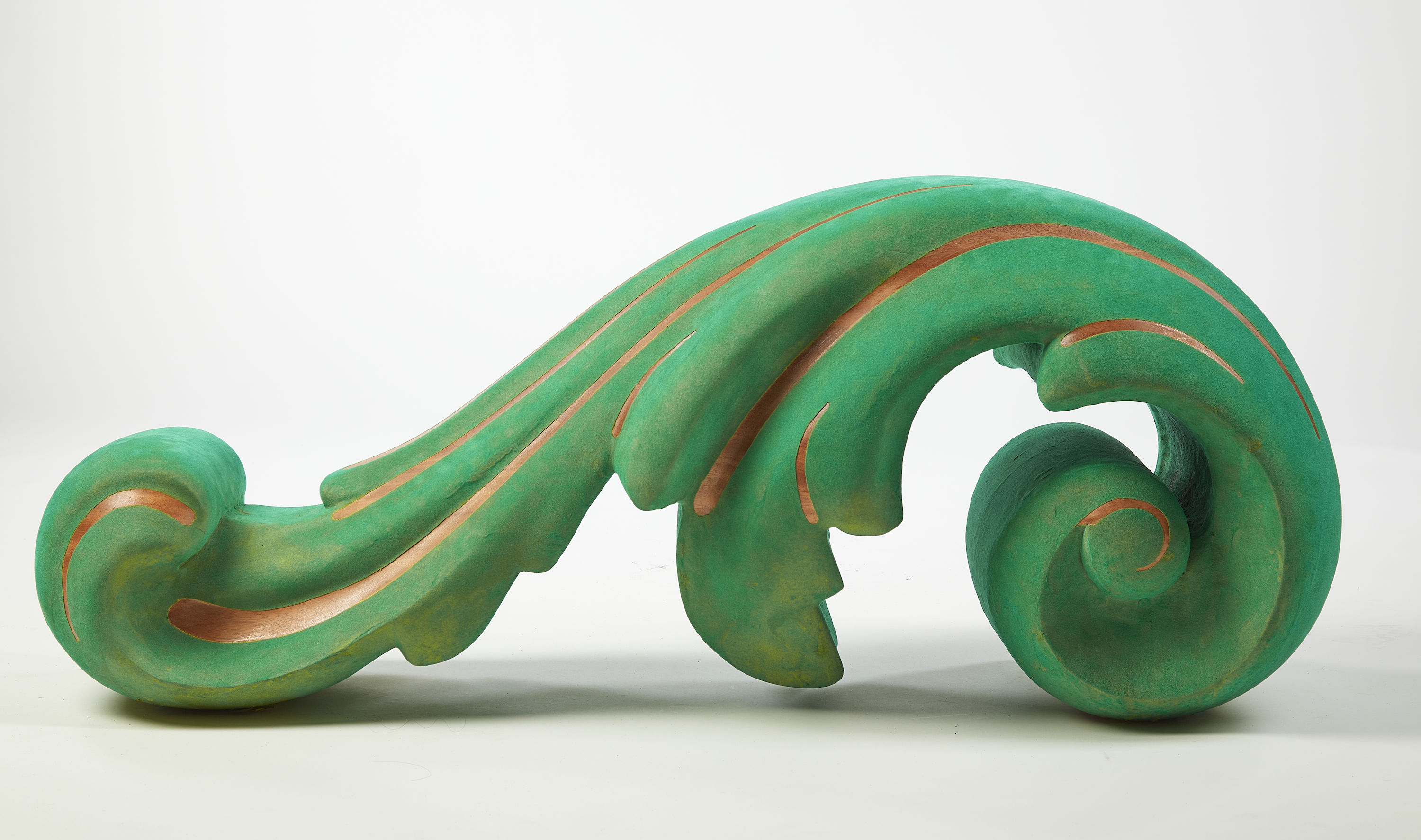 A large solid wood freestanding acanthus leaf ornament made of mahogany and coated in green flocking with detail linework exposing bare wood. 