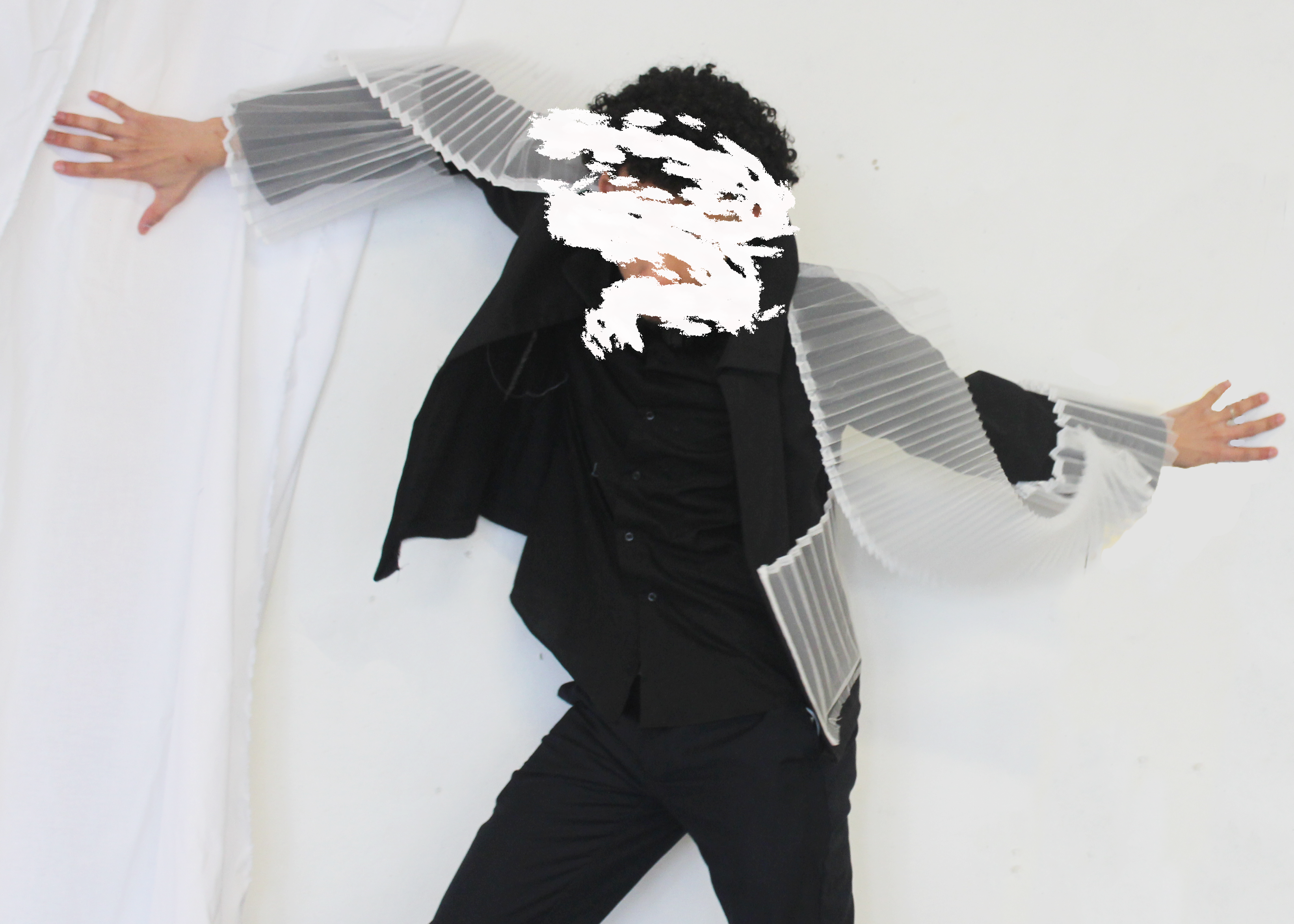 Student posing with back jacket with white pleated fabric wrapping around the arms
