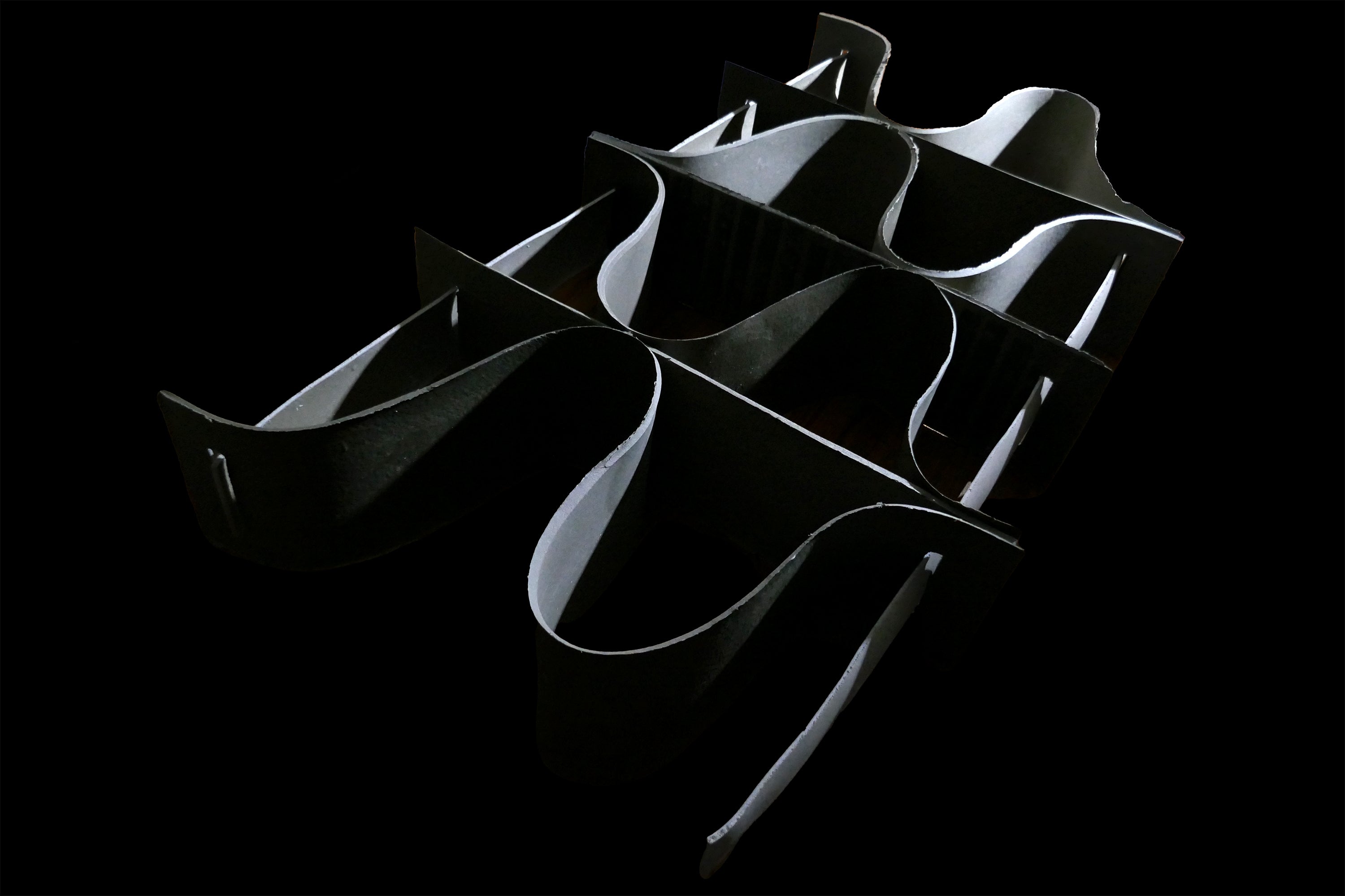 /A%20shelf%20composed%20of%20seven%20thin%2C%20curved%2C%20ribbon-like%20forms%20intertwined%20and%20overlapping%20against%20a%20black%20background.%20The%20oyster%20biomaterial%20Shellf%20Life%20has%20a%20reflective%2C%20silver-toned%20surface%20that%20catches%20the%20light%20for%20a%20beautiful%20furniture%20design.