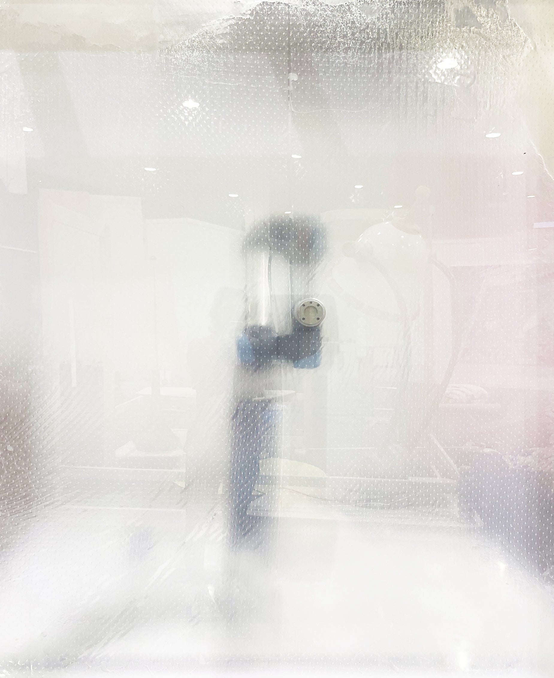A robotic arm seen through a semi-translucent lacey membrane. 
