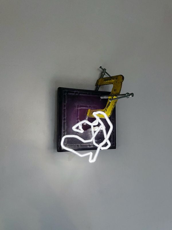 /a%20yellow%20three%20way%20clamp%20attached%20to%20a%20wooden%20frame%20inset%20into%20the%20wall%20with%20a%20skinny%20white%20light%20squiggle%20coming%20out%20of%20it.