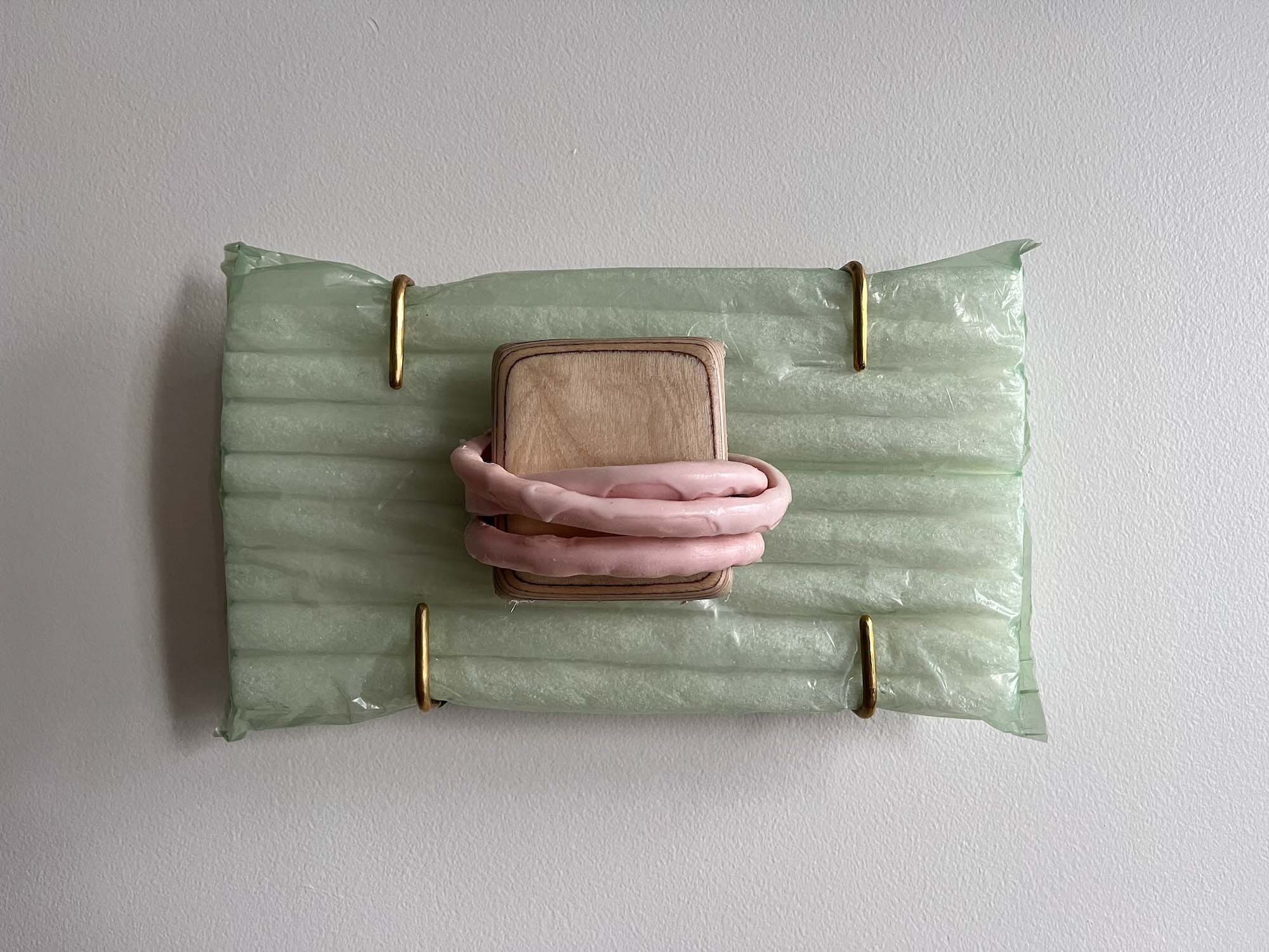 /a%20yellow%20three%20way%20clamp%20attached%20to%20a%20wooden%20frame%20inset%20into%20the%20wall%20with%20a%20skinny%20white%20light%20squiggle%20coming%20out%20of%20it.