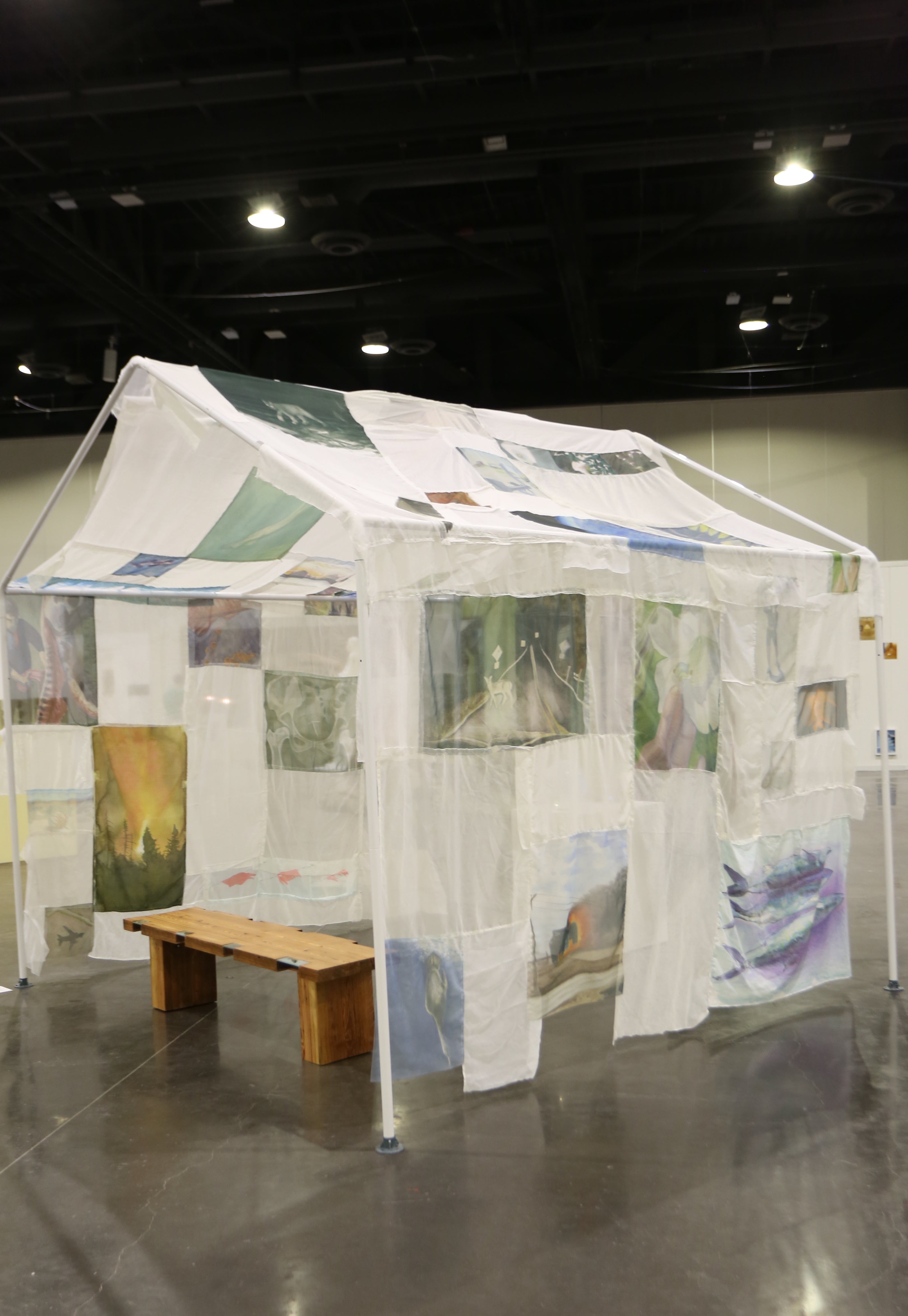 /Paintings%20on%20transparent%20fabric%20draped%20over%20house%20frame%20