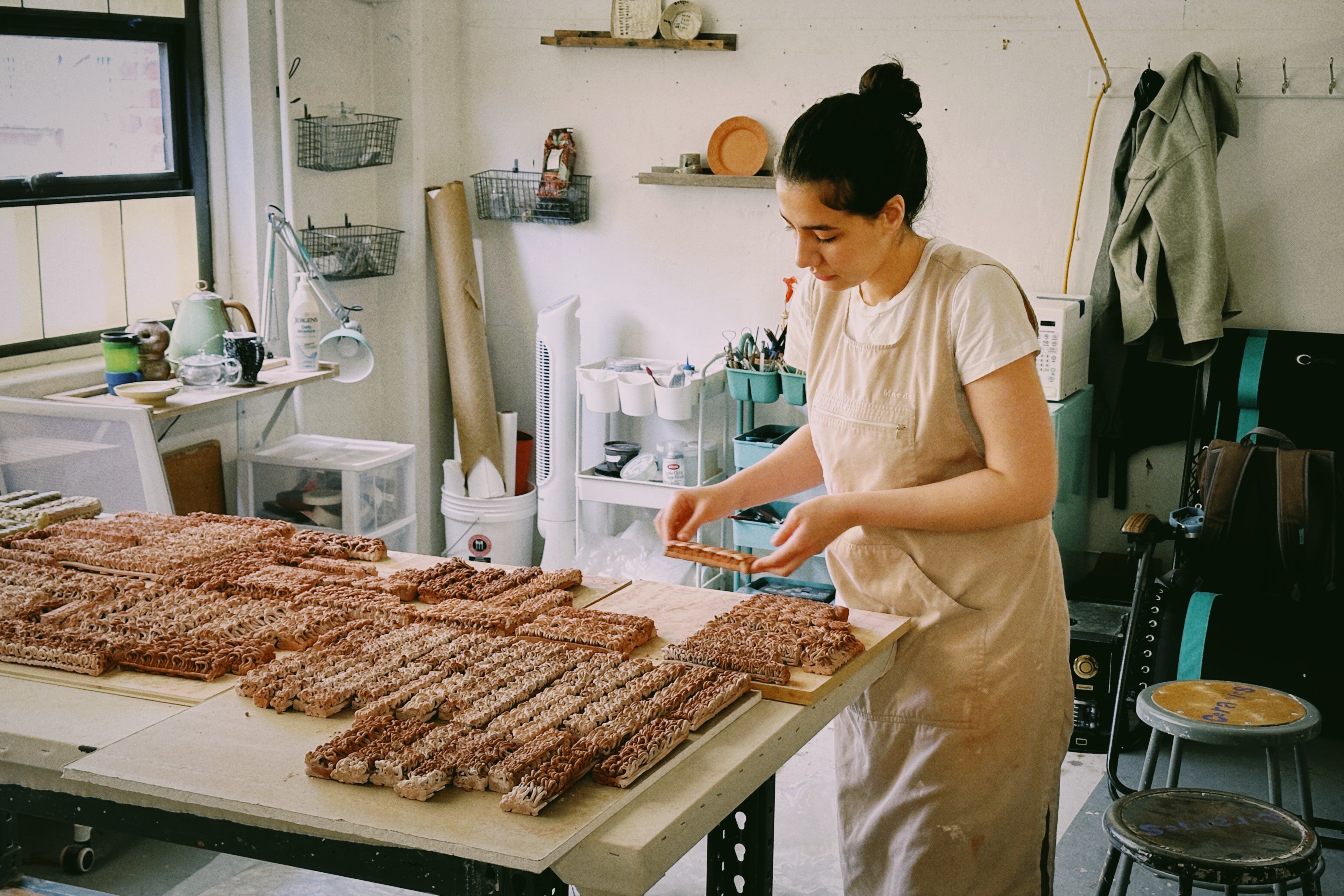 /Artist%20arranging%20clay%20pieces%20on%20a%20table%20in%20a%20well-lit%20studio%2C%20surrounded%20by%20tools%20and%20materials%2C%20creating%20an%20organized%20and%20creative%20workspace