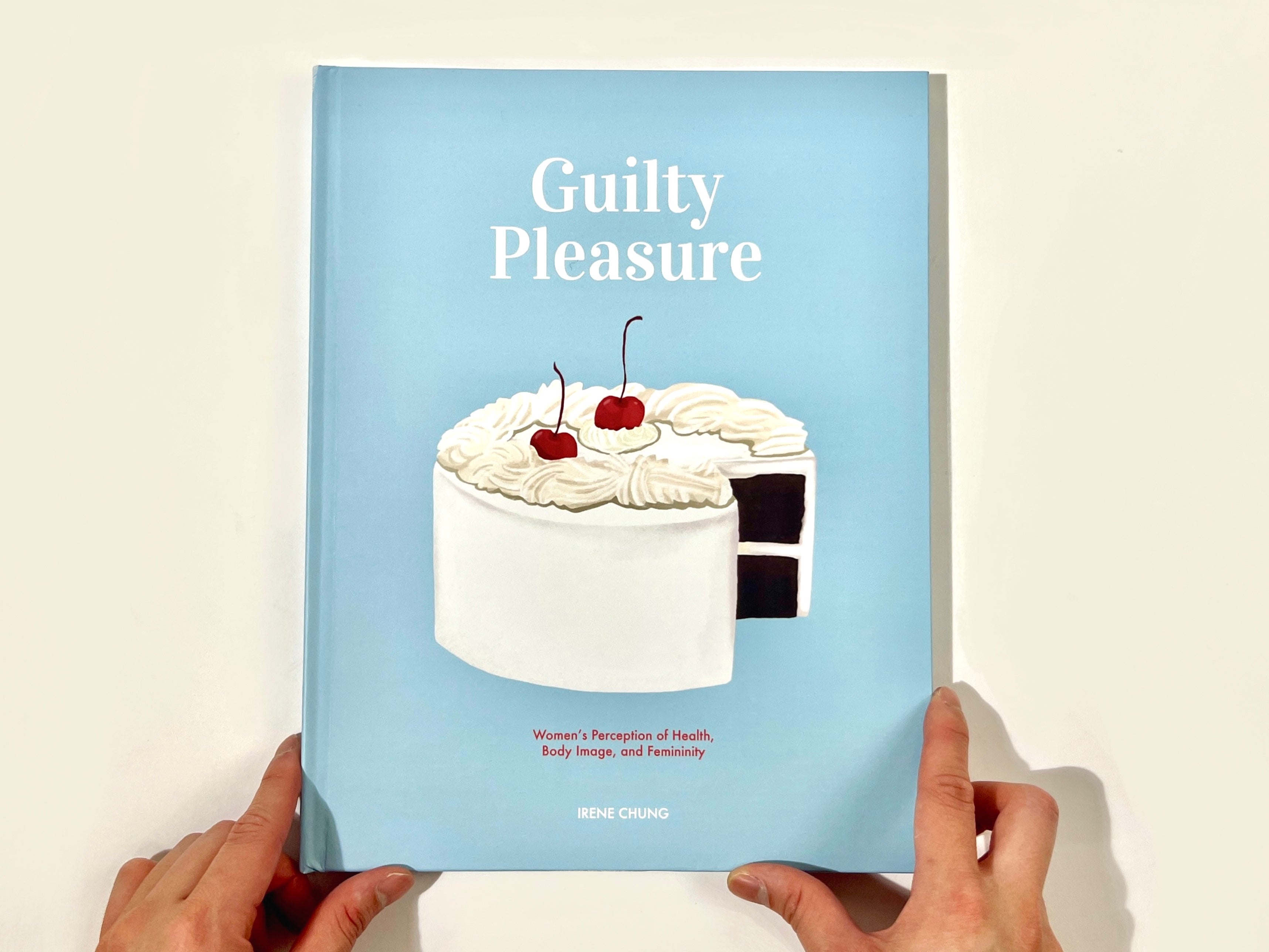 /A%20photograph%20of%20the%20book%20cover%2C%20which%20features%20a%20creamy%20white%20cake%20with%20cherries%20on%20top%2C%20sitting%20on%20a%20baby-blue%20background