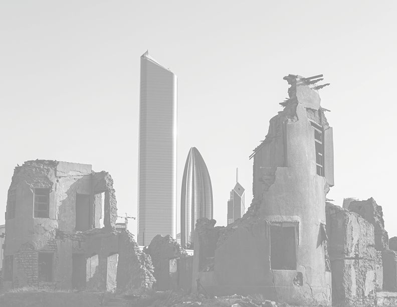 Black and white image of building in ruins, set against the back drop of the Kuwait city skyline.
