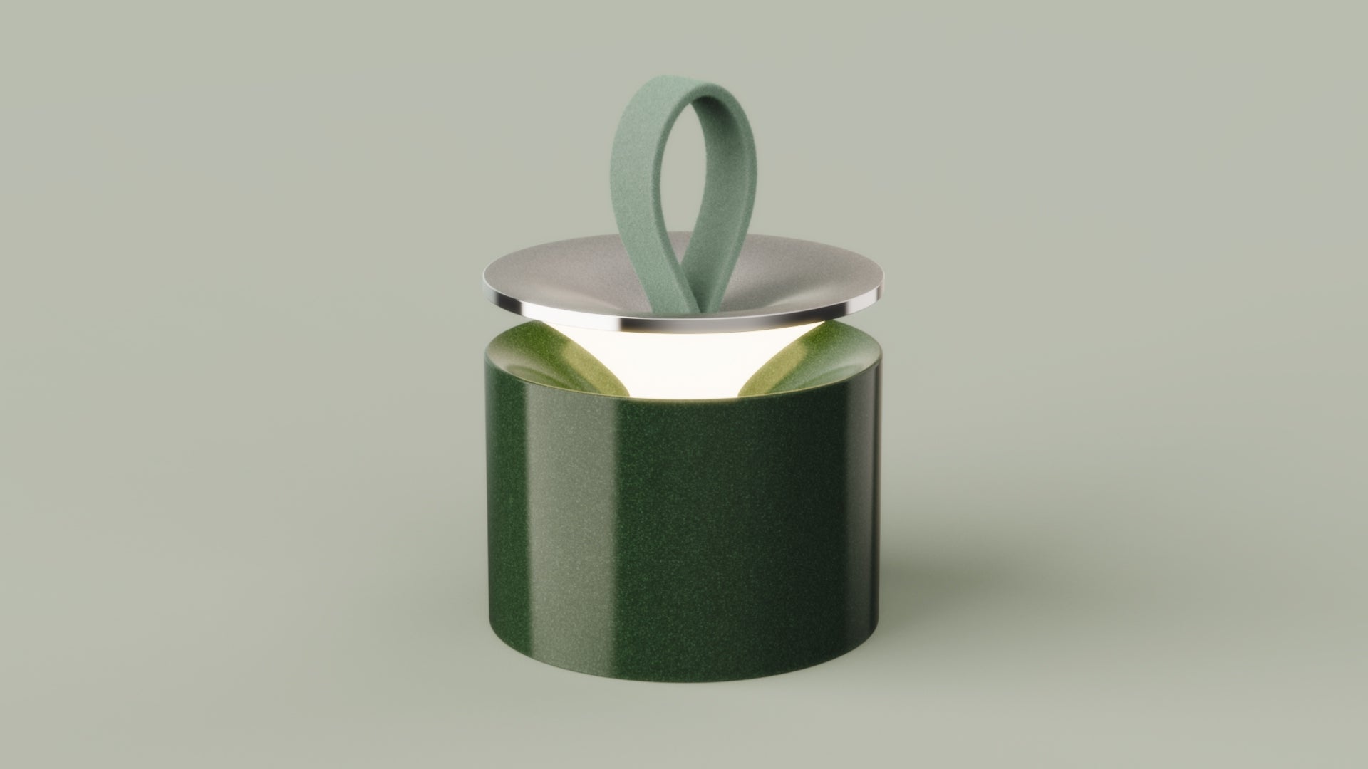 A glossy green ceramic lamp with a soft felt loop handle and lifted metal lid, glowing warmly from within.