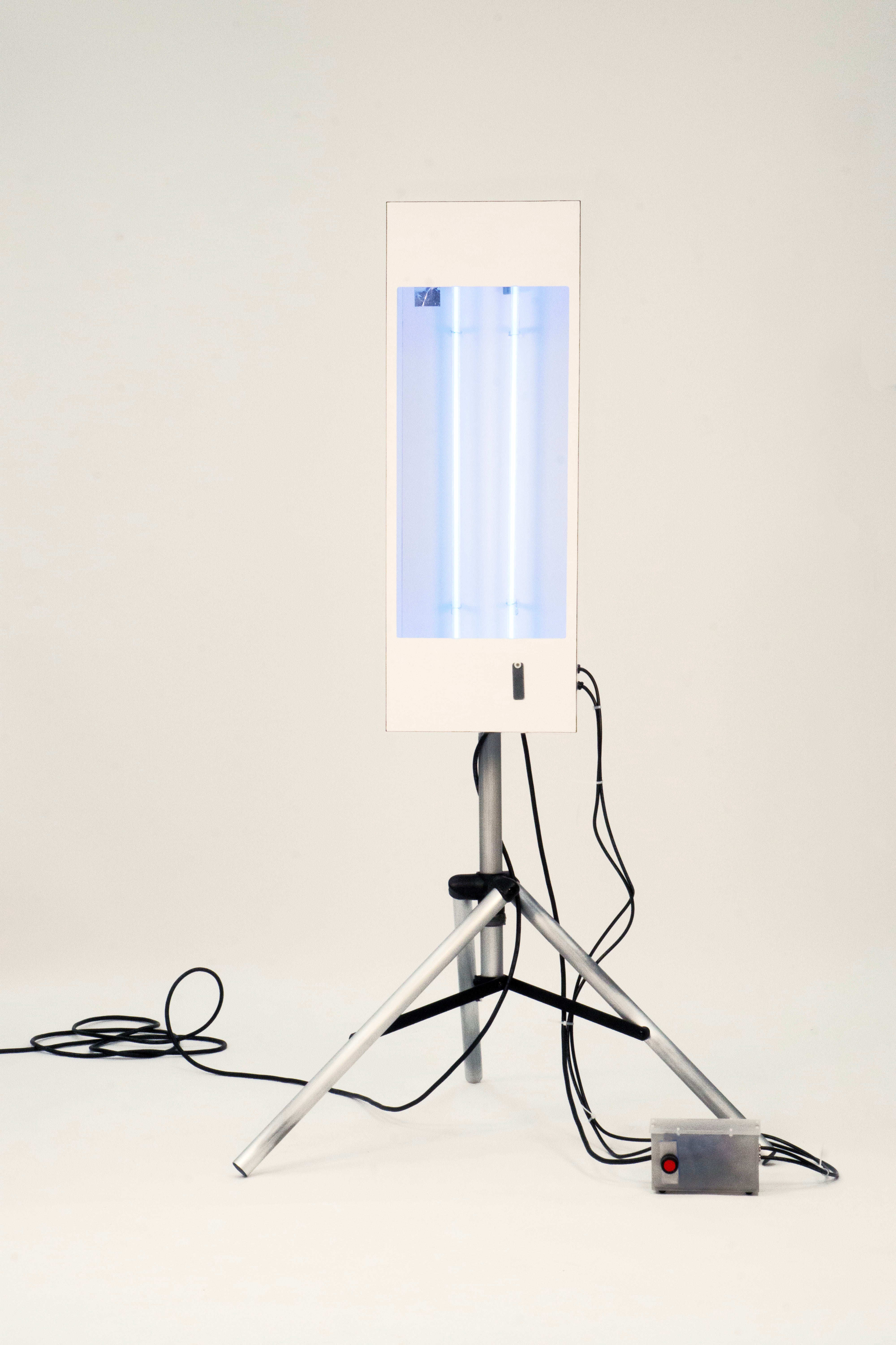 White box mounted on aluminum tripod with two blue neon tubes inside