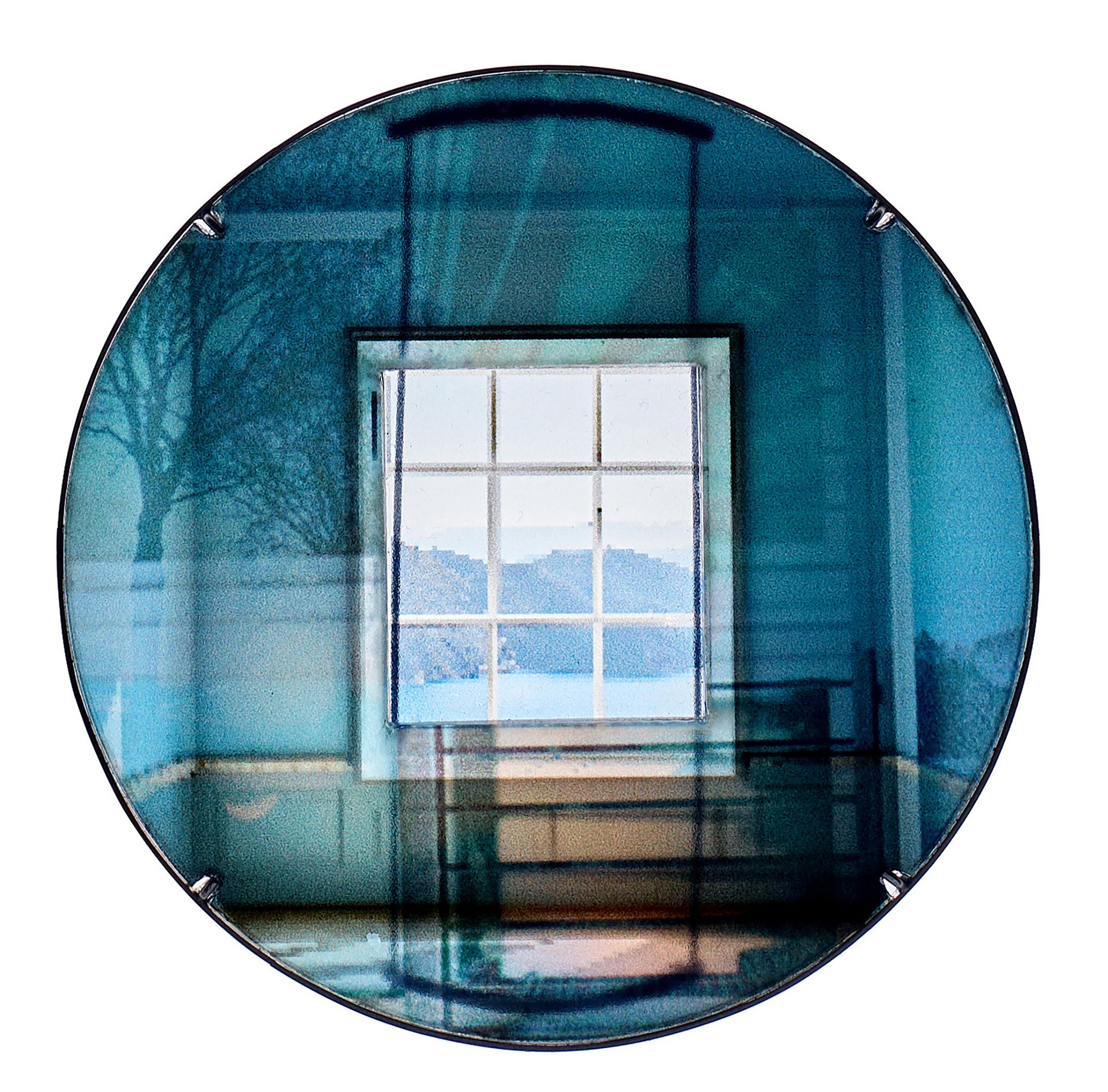 Blue circular brooch showing a square window view, with layered tree shadows and abstract light blending in a dreamlike room.