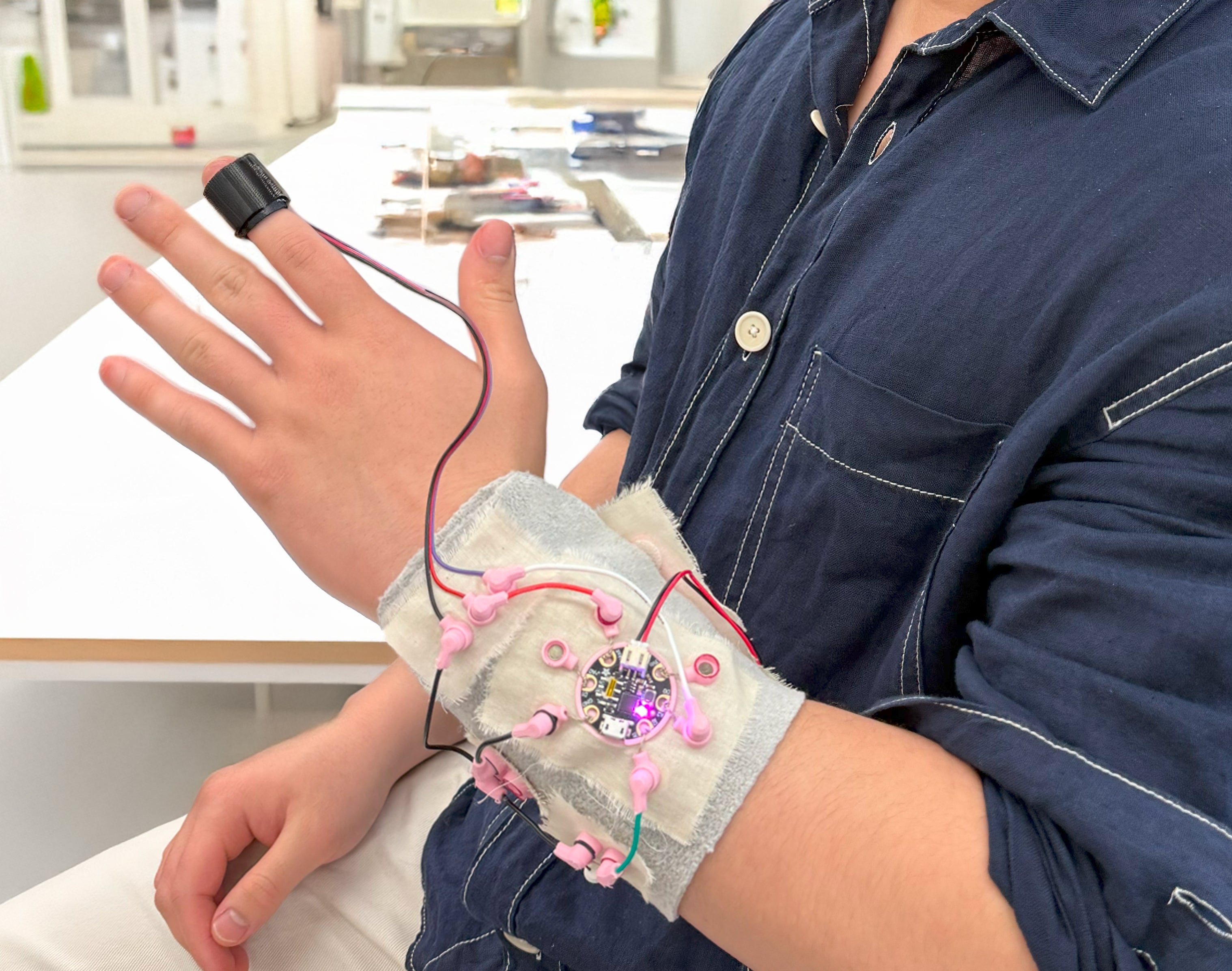 Electronic components on fabric wrapped around outstretched hand to created haptic pulse sensor prototype