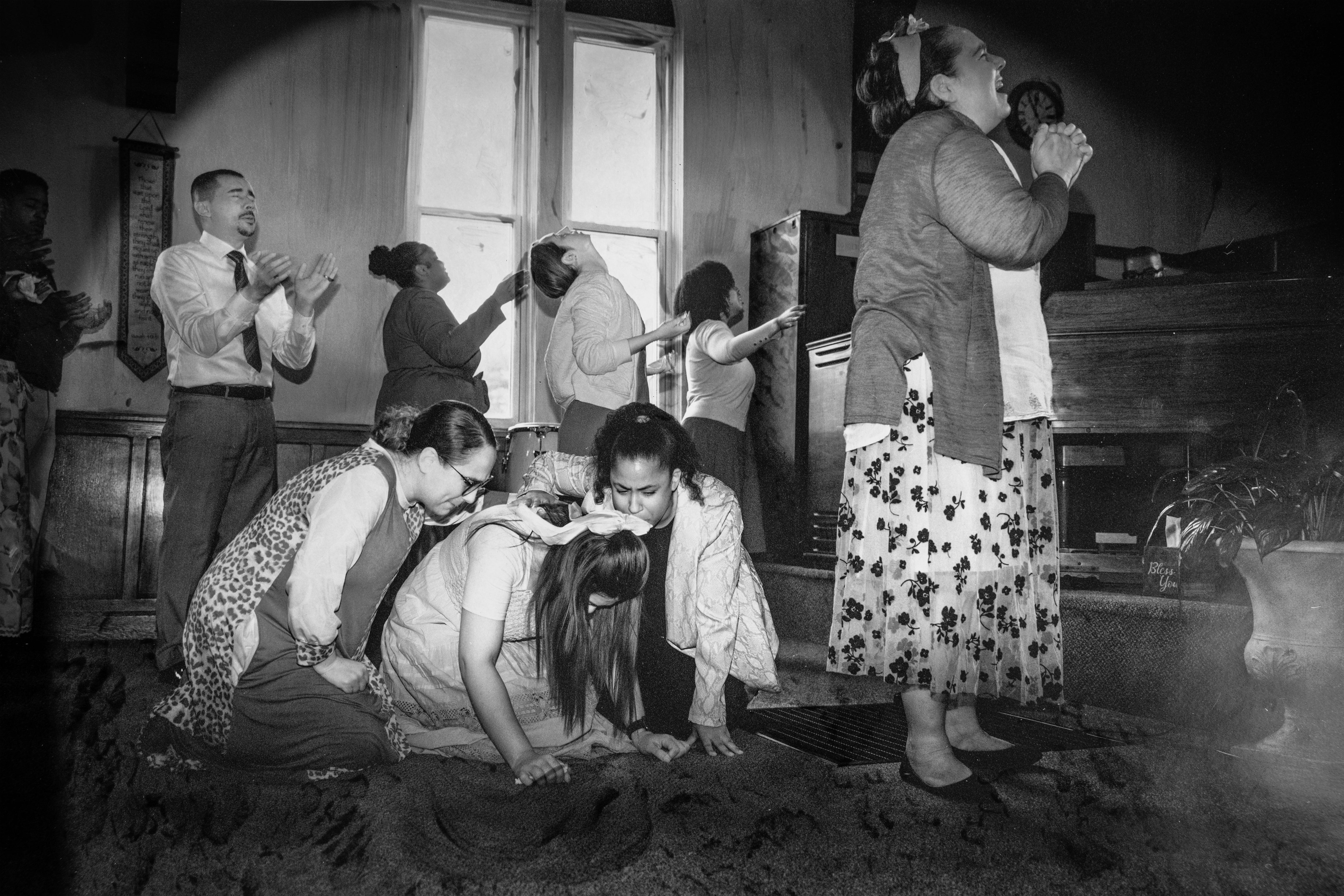A ribbon in her hair, she falls weeping, held by sun; a procession of worshippers turn faces to God, a click, a pop of light.