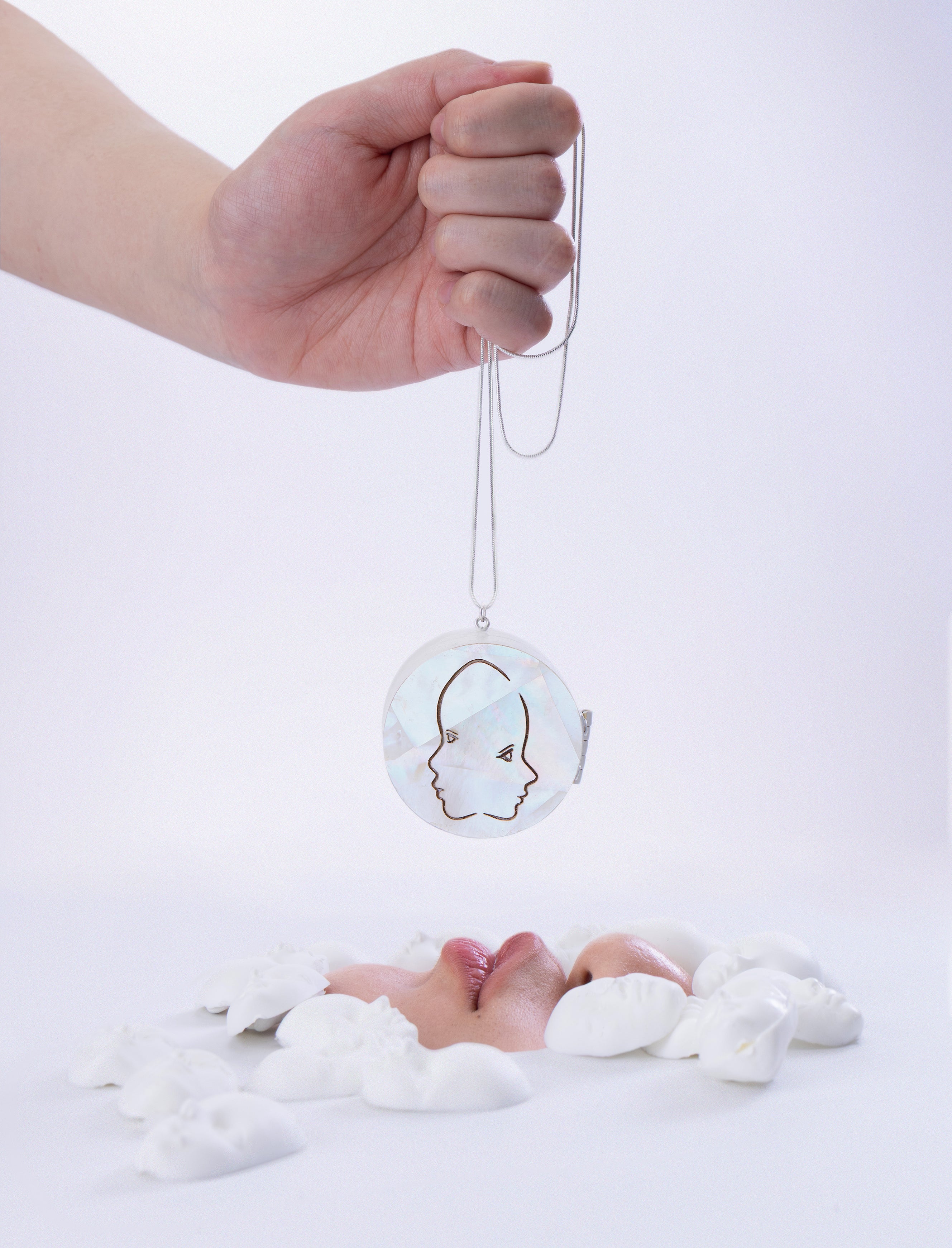 Mother-of-pearl embellished locket necklace, with laser-engraved pattern of two side faces. 