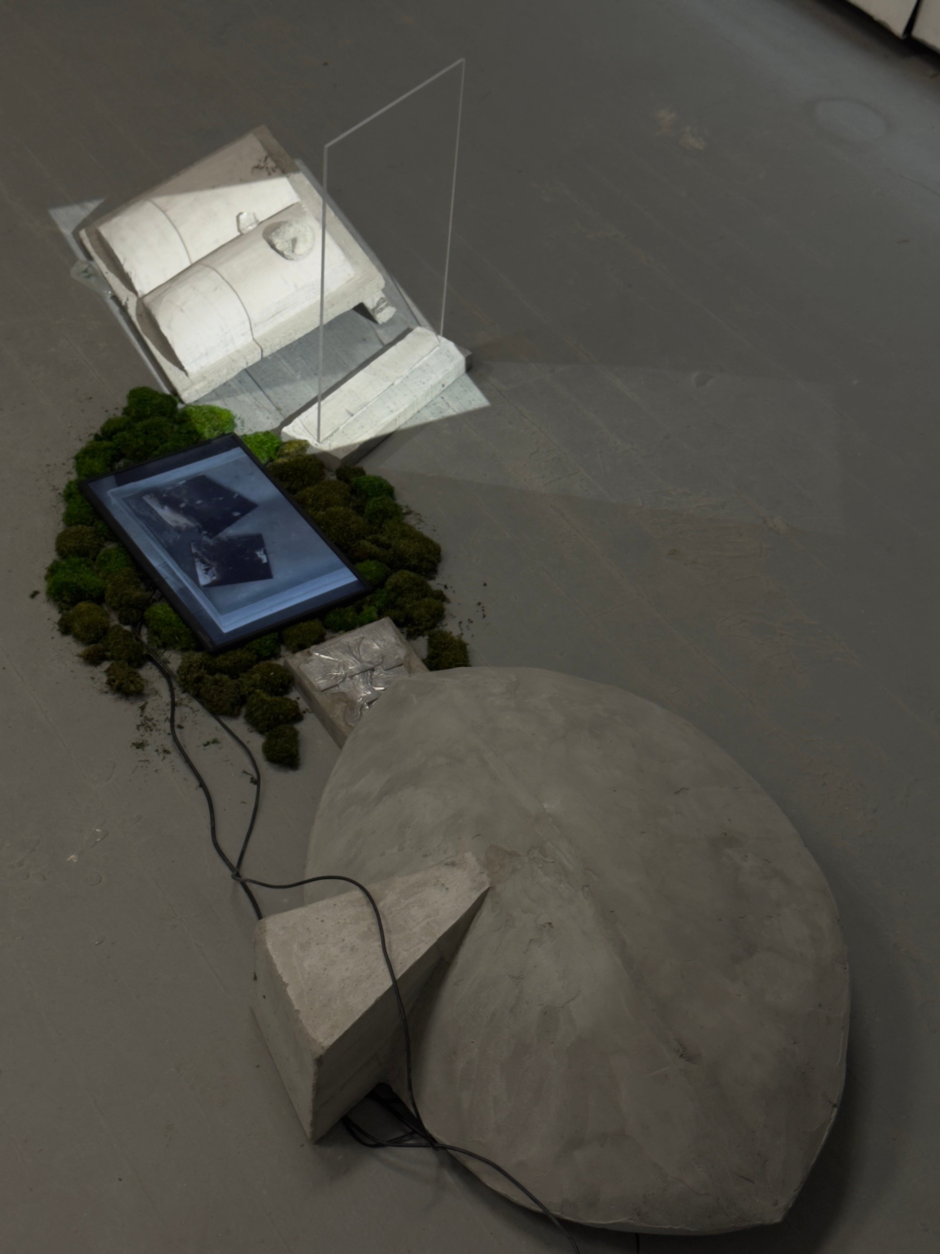 Concrete dome, moss-framed screen with floating mirrors, and book-like slab lit by dripping water’s shadow through glass.