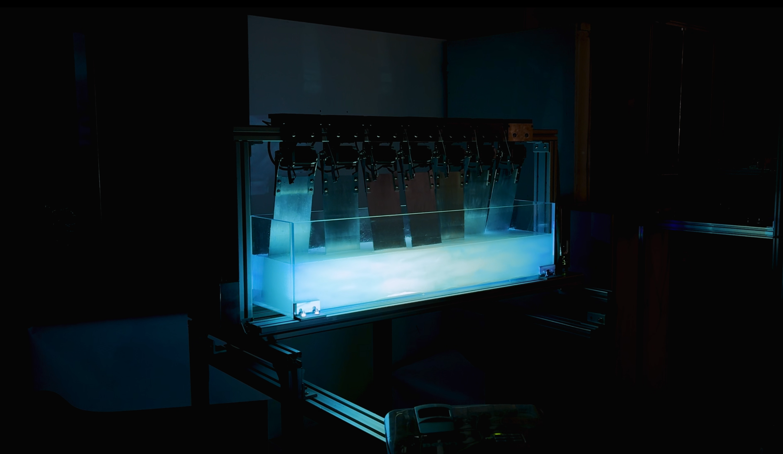 The liquid emitting blue light moves in the tank with the swinging of the metal panels, based on an aluminum structure.