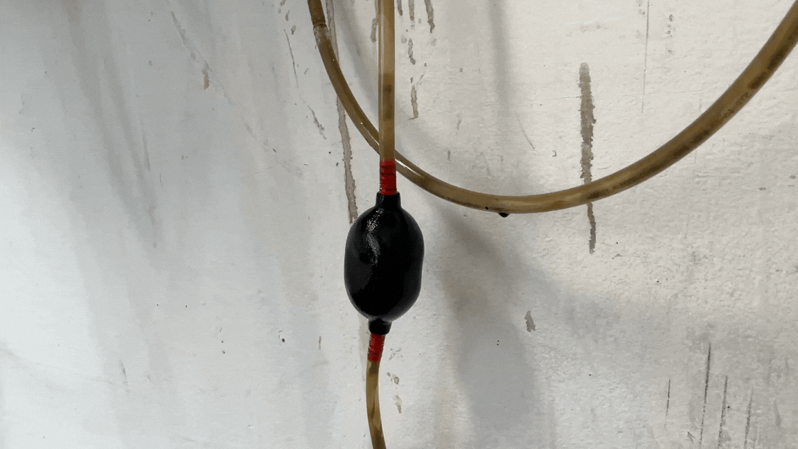 Video Clip of the Piece Tire Pee II in motion, motor oil pumps through a small siphon, the siphon breaths in and out helping the liquid flow through the sculpture. 