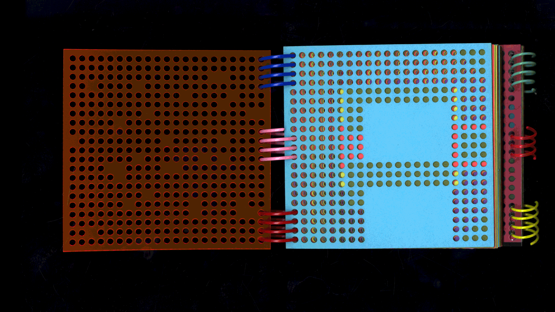 Several pages of a book made of colored paper feature letters of the alphabet on each page. The pages are perforated, and the letters are formed by the holes. 