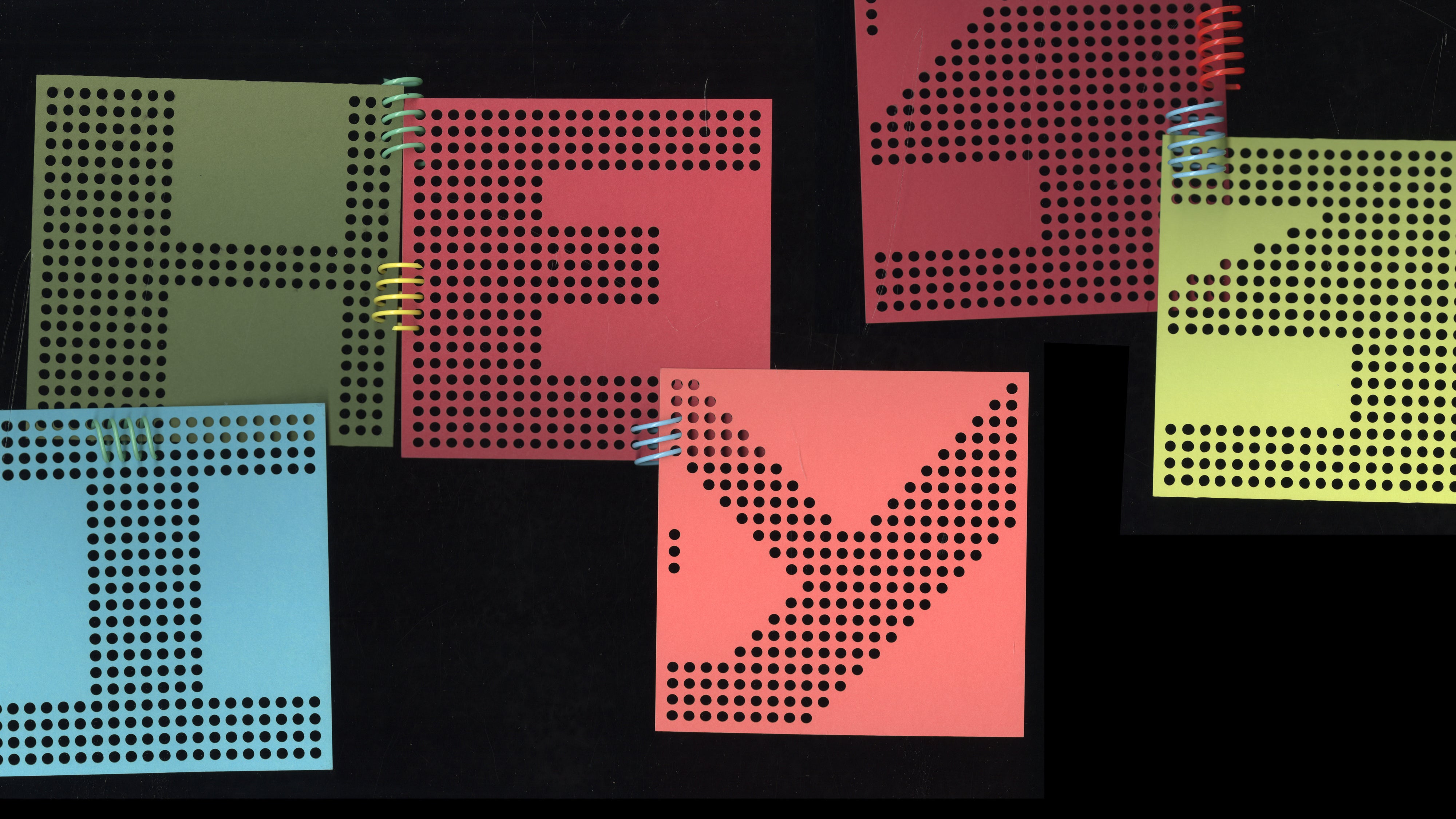 Colored, perforated papers, each with a letter, form the words “Hey,” “Hi,” and the number 13. The papers are held together by pieces of colored coil binding. 