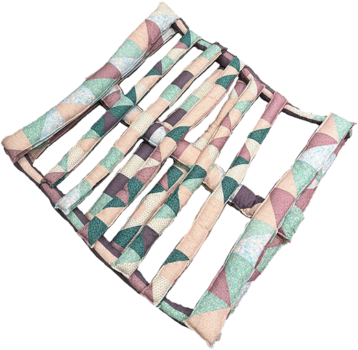 Soft quilted sculpture shaped like a wooden shipping pallet, made from pastel patterned fabric. 