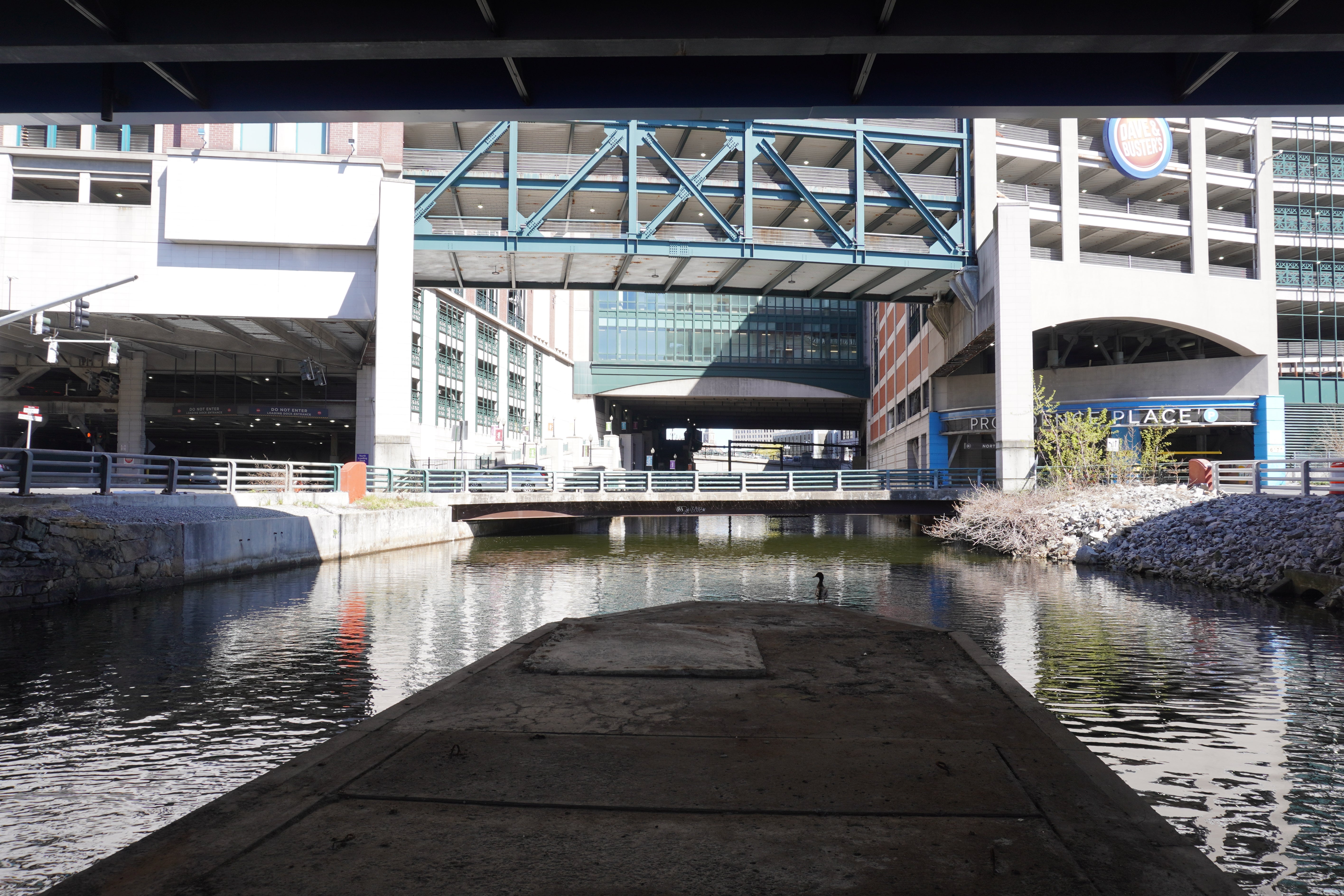 A photograph of the river running beneath the Providence Place mall under the structure above.