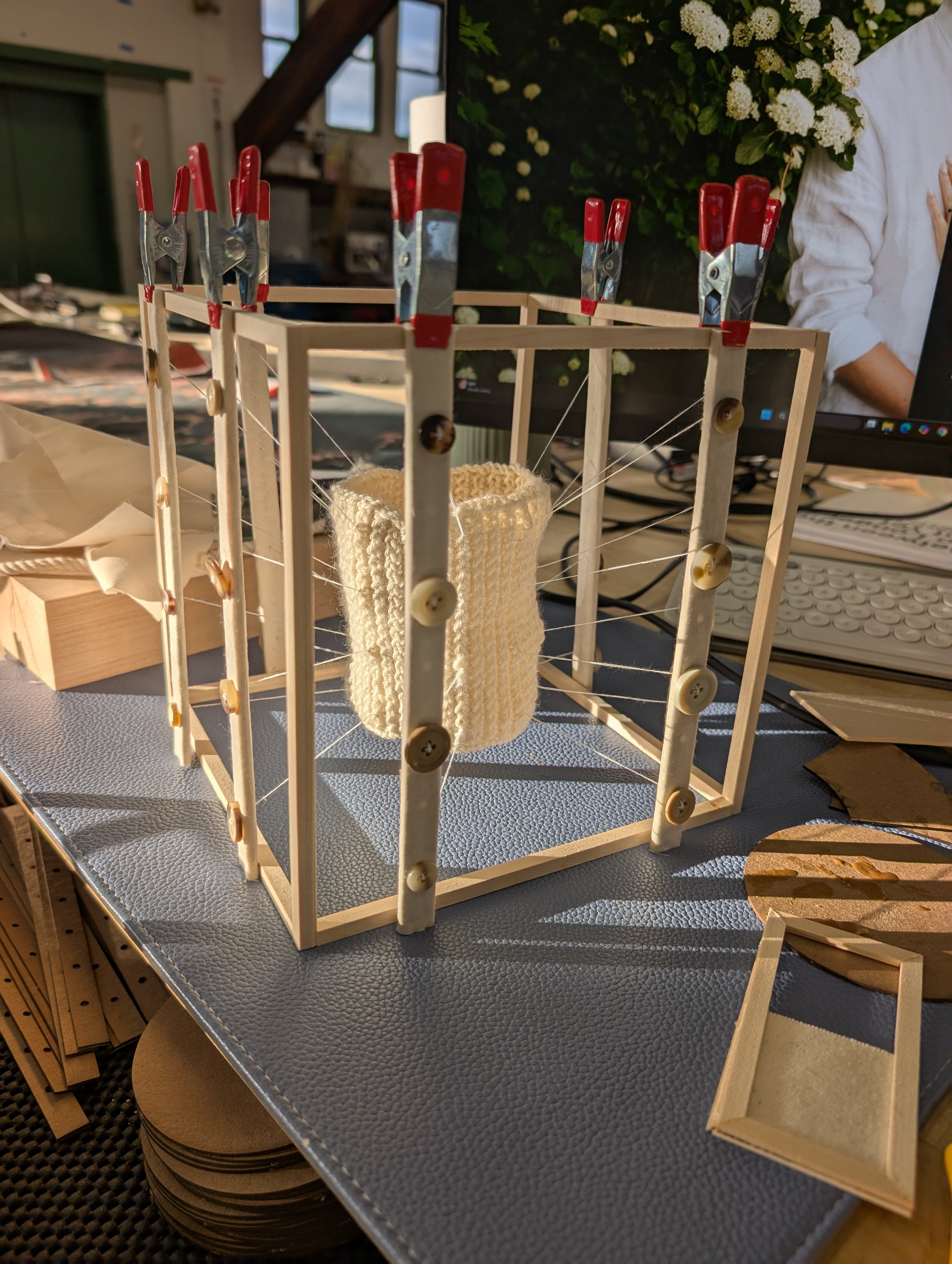 A model with a wooden frame in that supports a pulley system attached to a knitted tube. The tube is kept in tension by the frame and pulley system. 