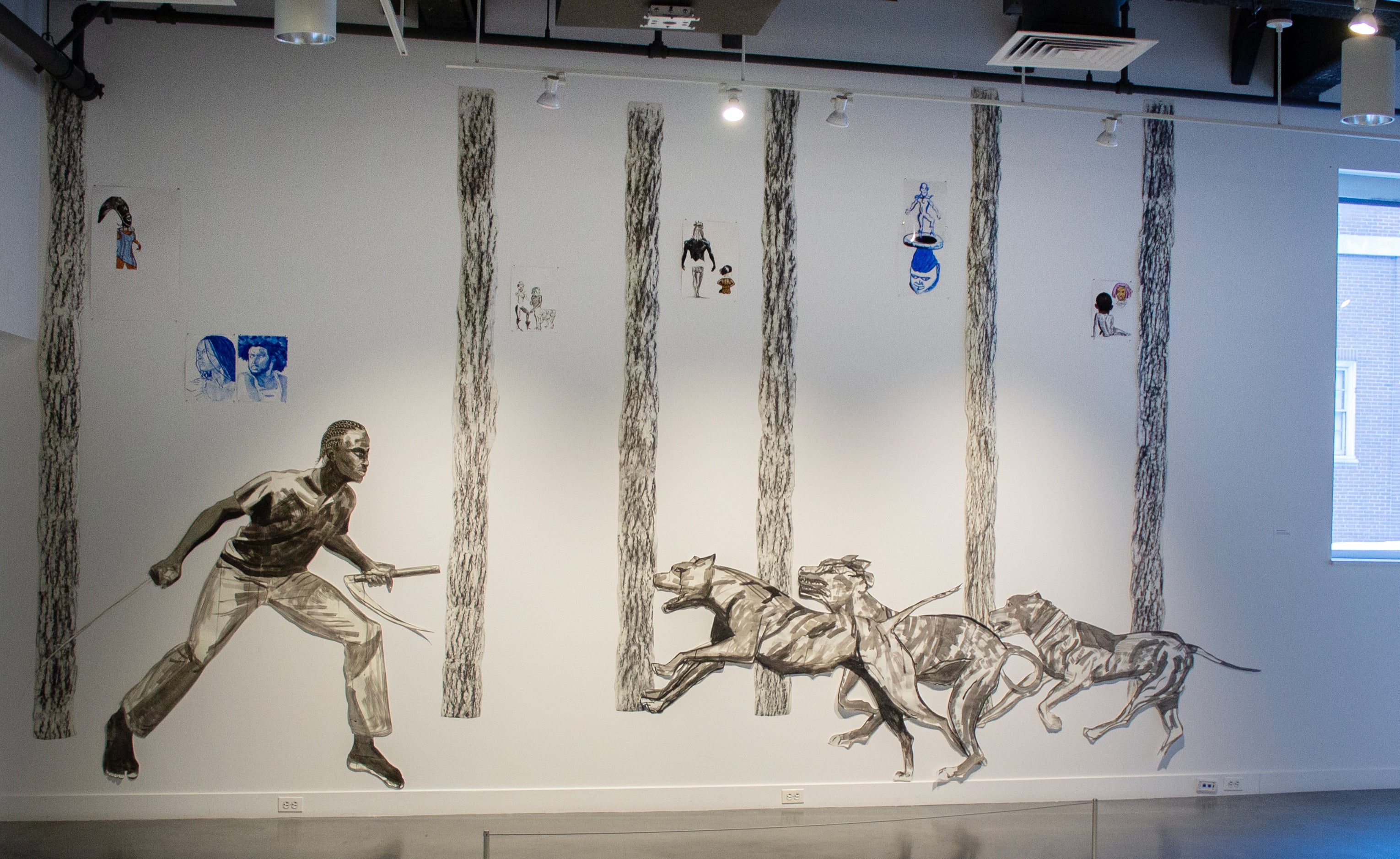 From left to right, a barefoot black figure with cornrows  faces three hounds running towards him in a forest. He has a scythe in each hand, ready to defend himself.