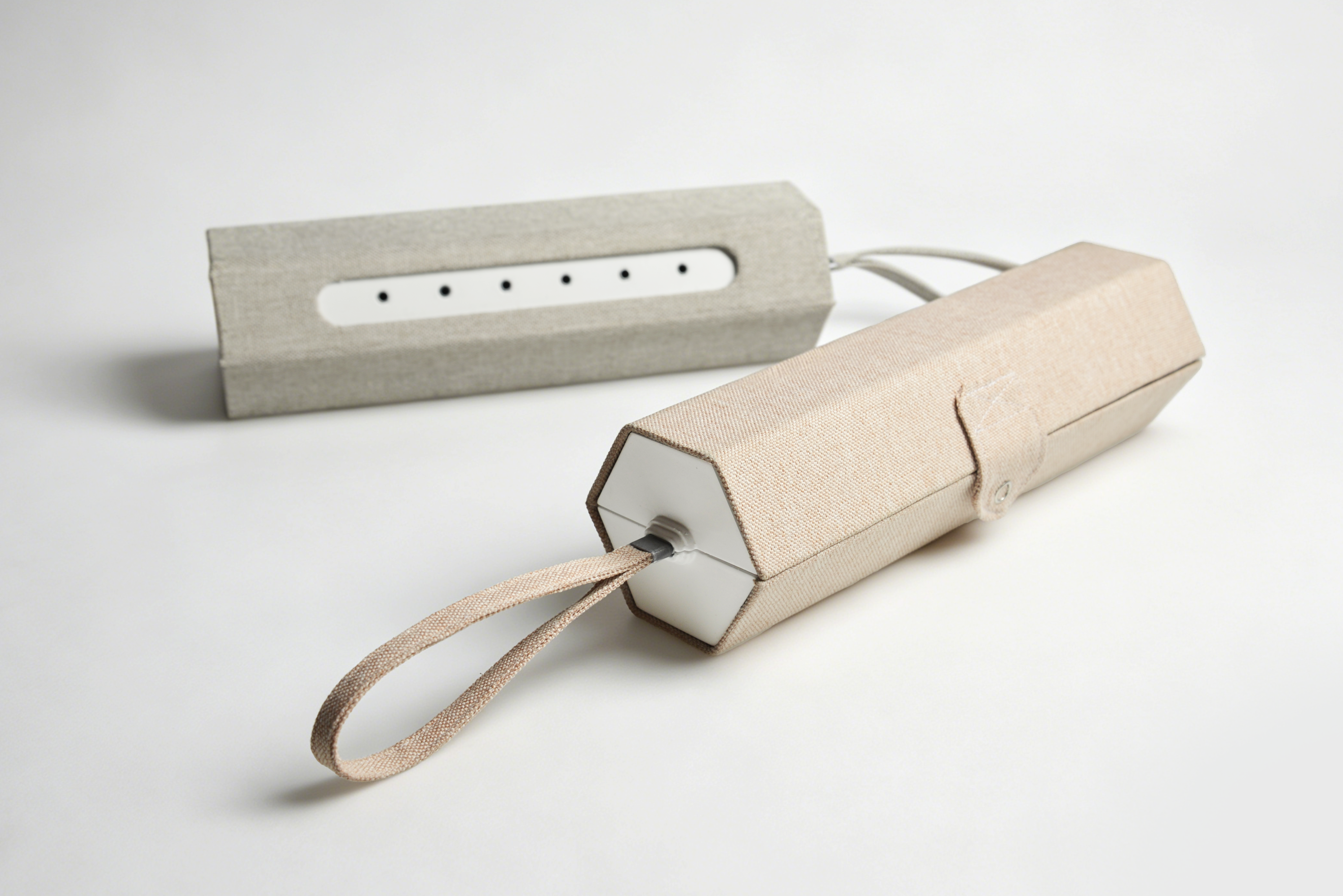 Soft, fabric-covered steam device cases in beige and gray, each with a strap, button closure, and ventilation holes. 