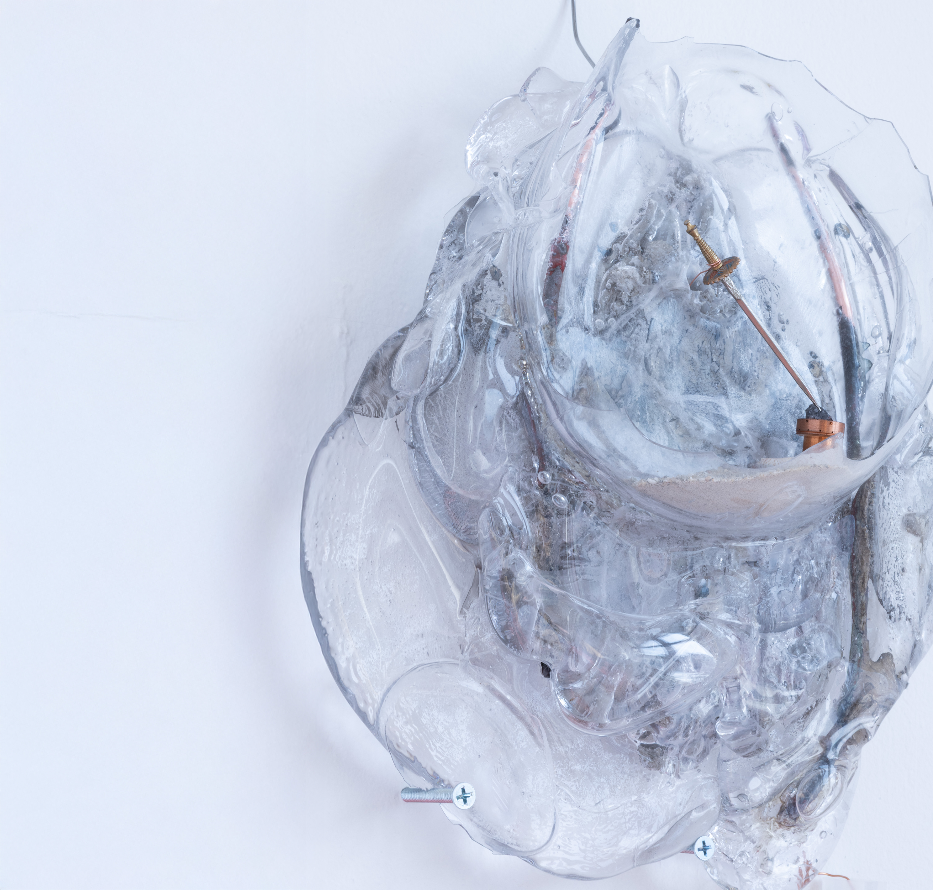 Formless glass lump with wires, and a pocket with sand and a tiny sword