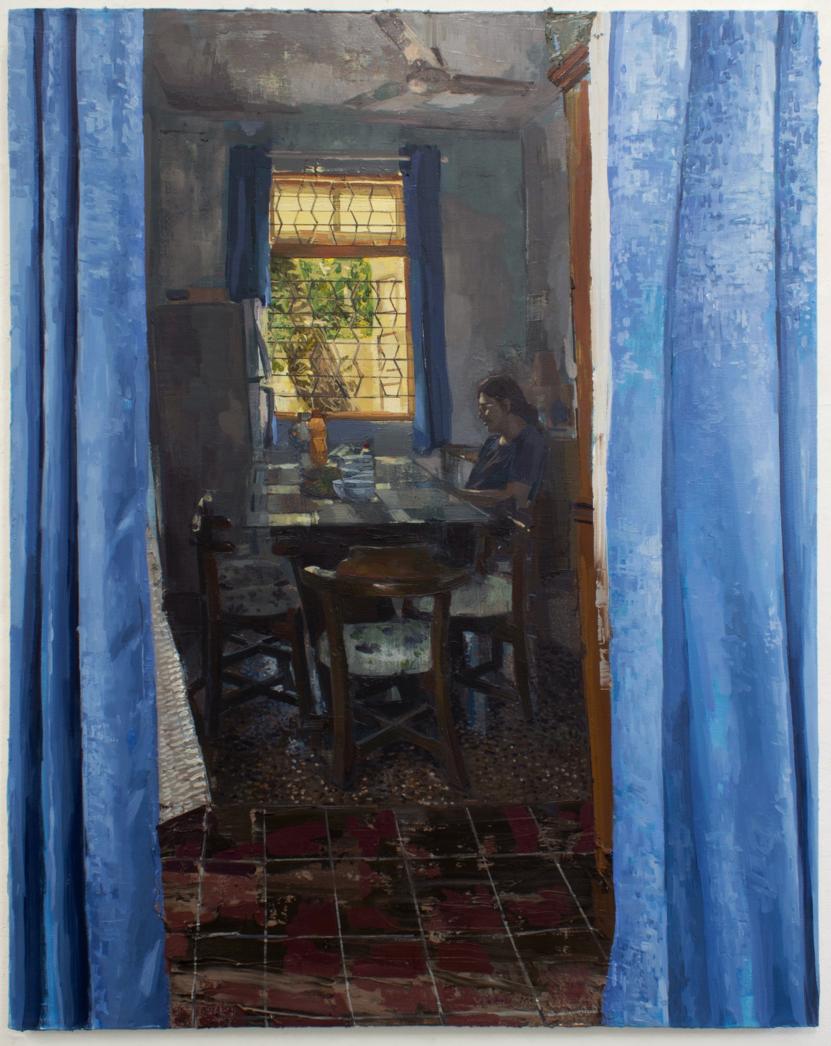 Figure sitting at a dining table next to a window being looked at through blue curtains.