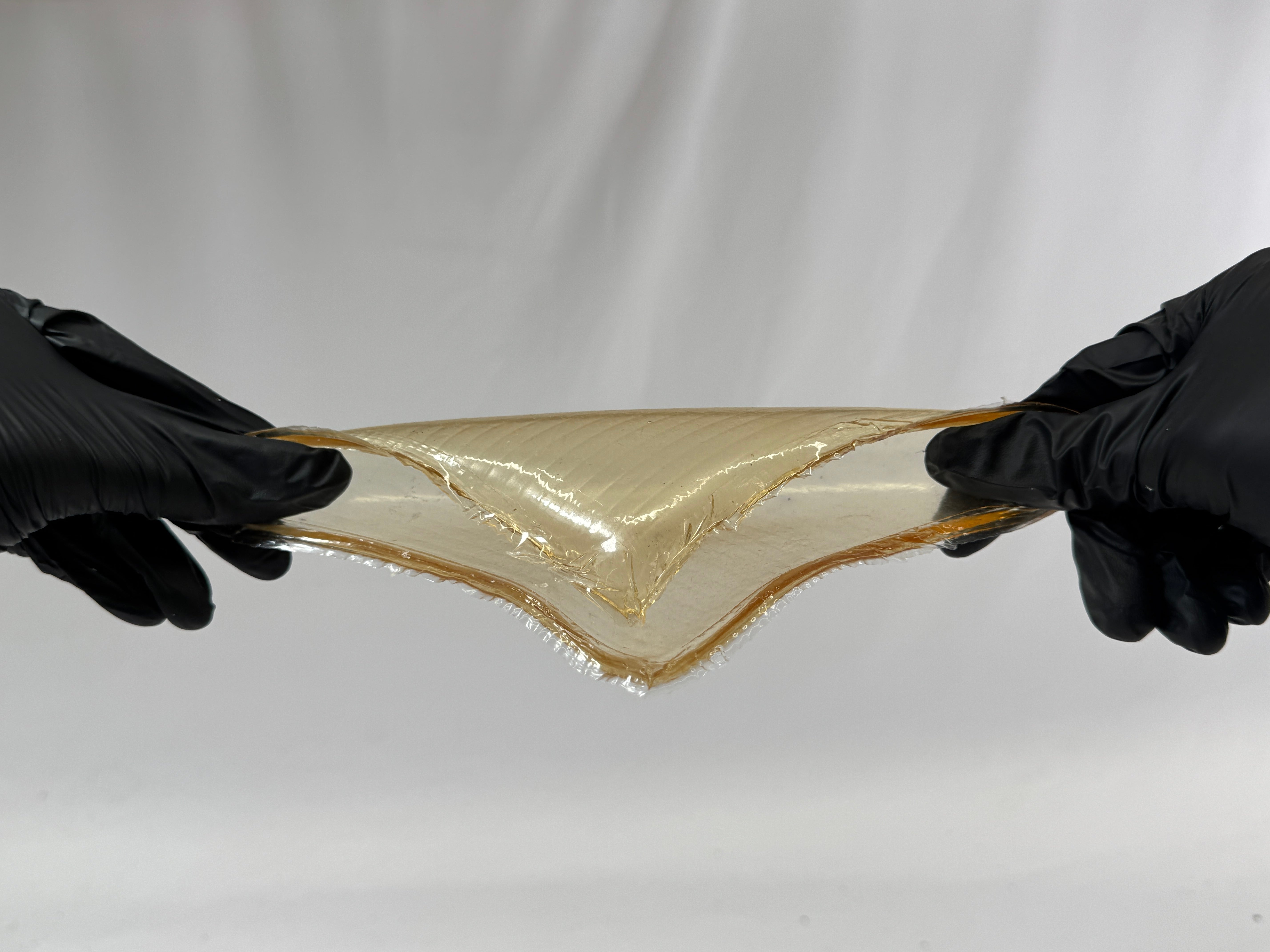 A simple tensile test on a bioplastic made primarily from gelatin. 6 inches by 6 inches. The addition of glycerin provides it with strong tensile properties. The material yellowed noticeably due to oxidation caused by excessive heating.