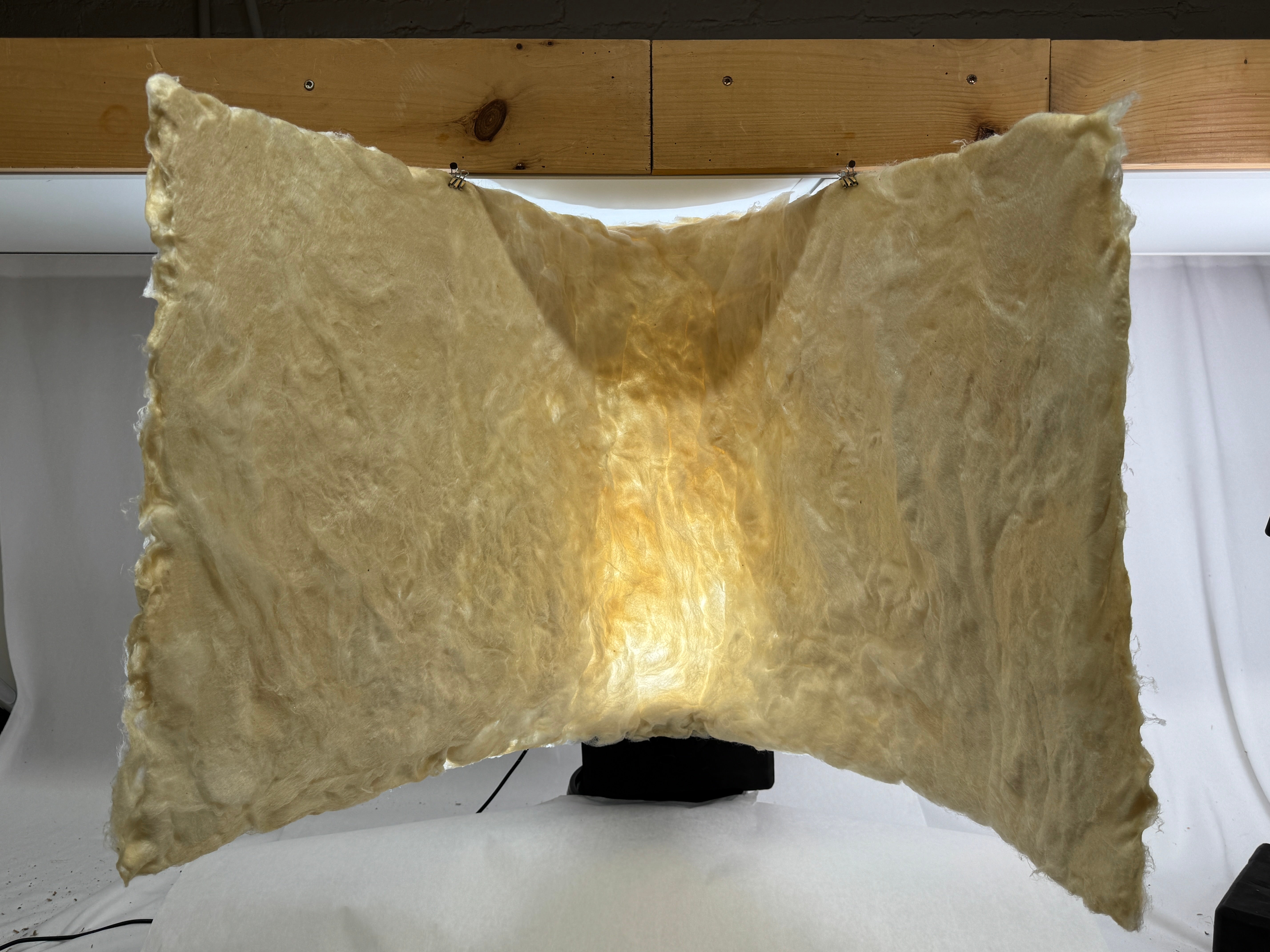 A material made primarily from wool and gelatin. 21 inches by 45 inches. The material is thick and has a high wool density. The gelatin has yellowed due to heat exposure. Thanks to the wool’s excellent sound-absorbing properties, this material will be placed on either side of the wearer’s ears in the final “shelter” design to reduce noise.