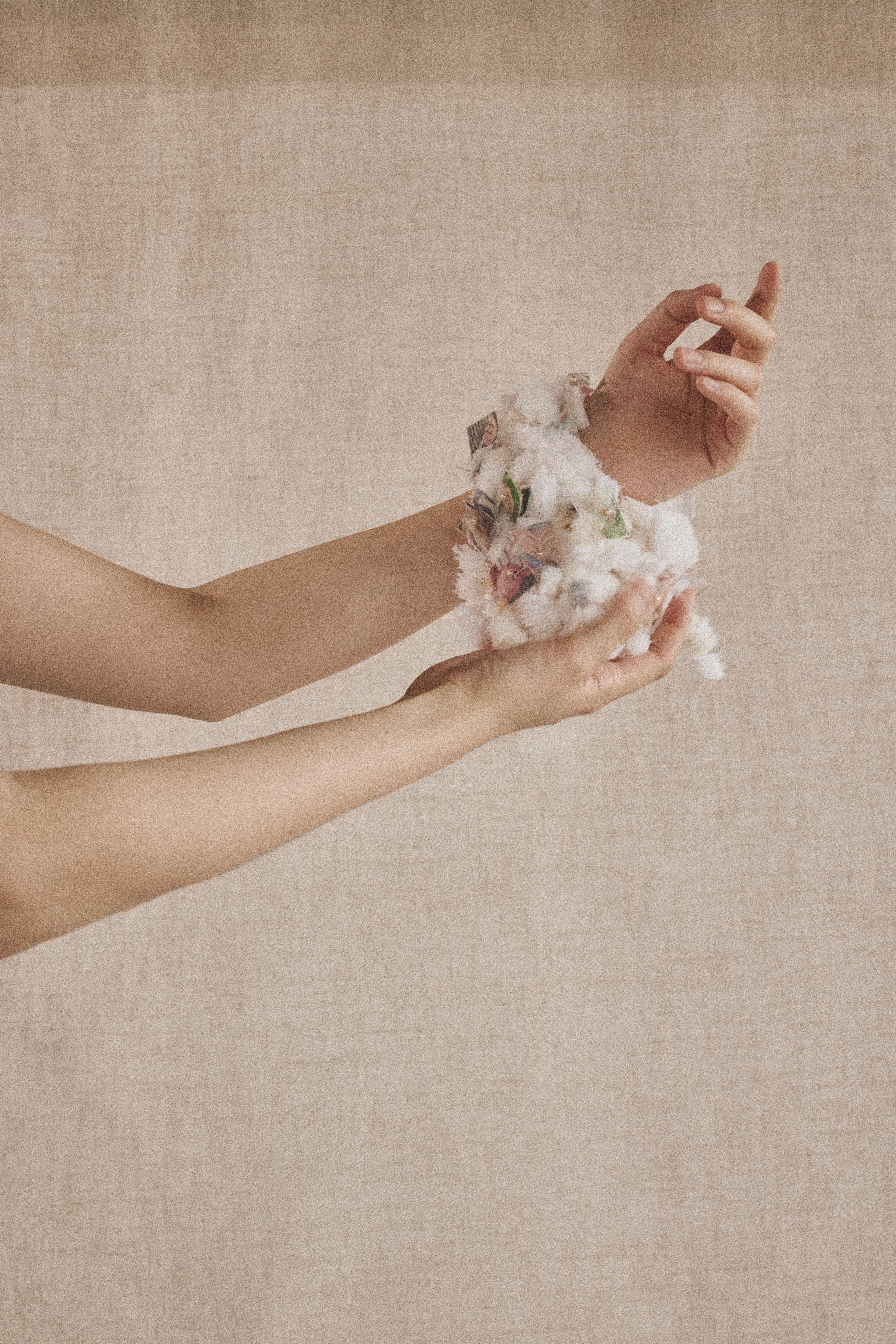 hands holding a delicately sewn together clump of fabric