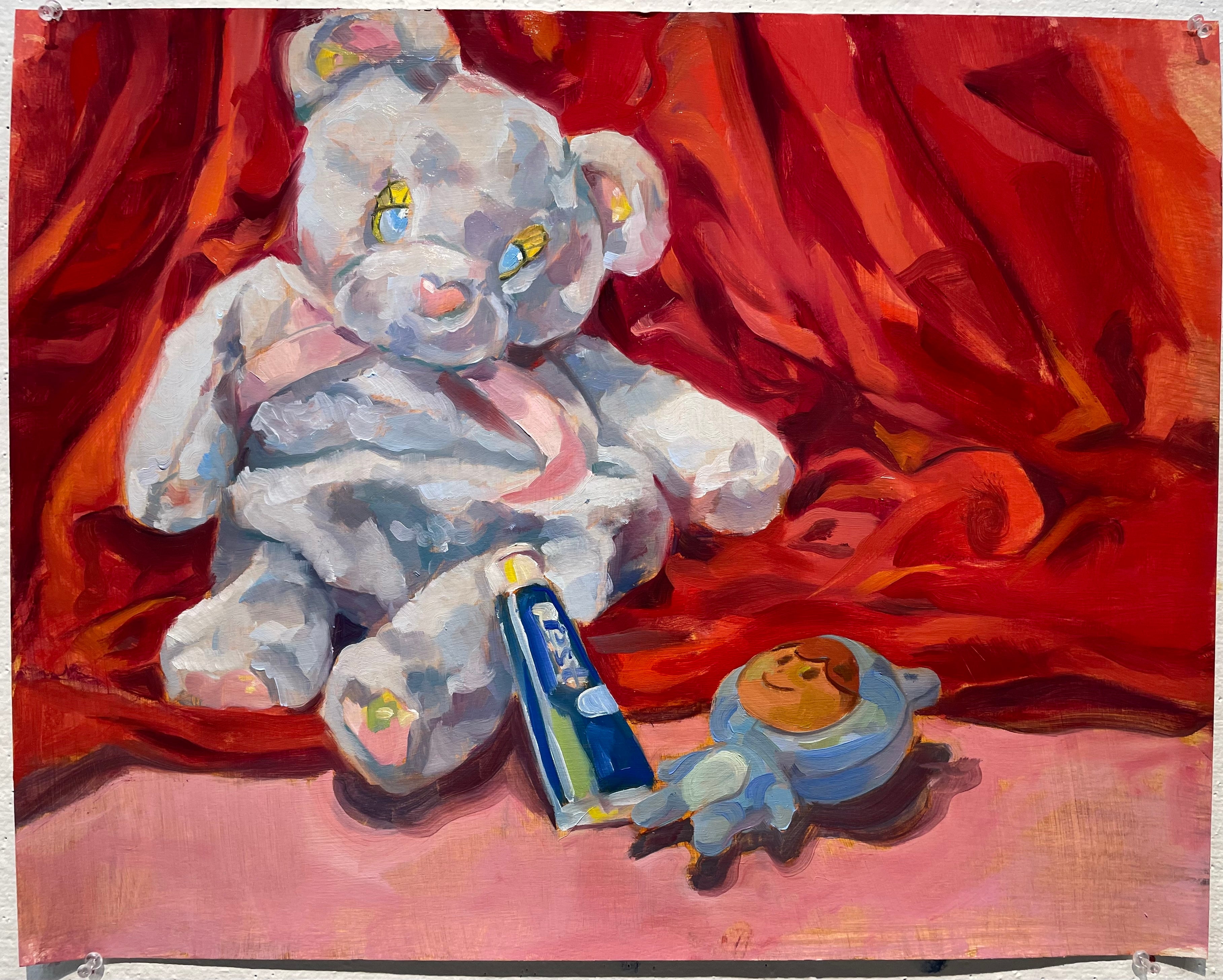 Still life with red fabric background and blue color objects in front consisting of a toy bear, blue stuffie and toothpaste bottle. Oil paint on gessoed canvas.