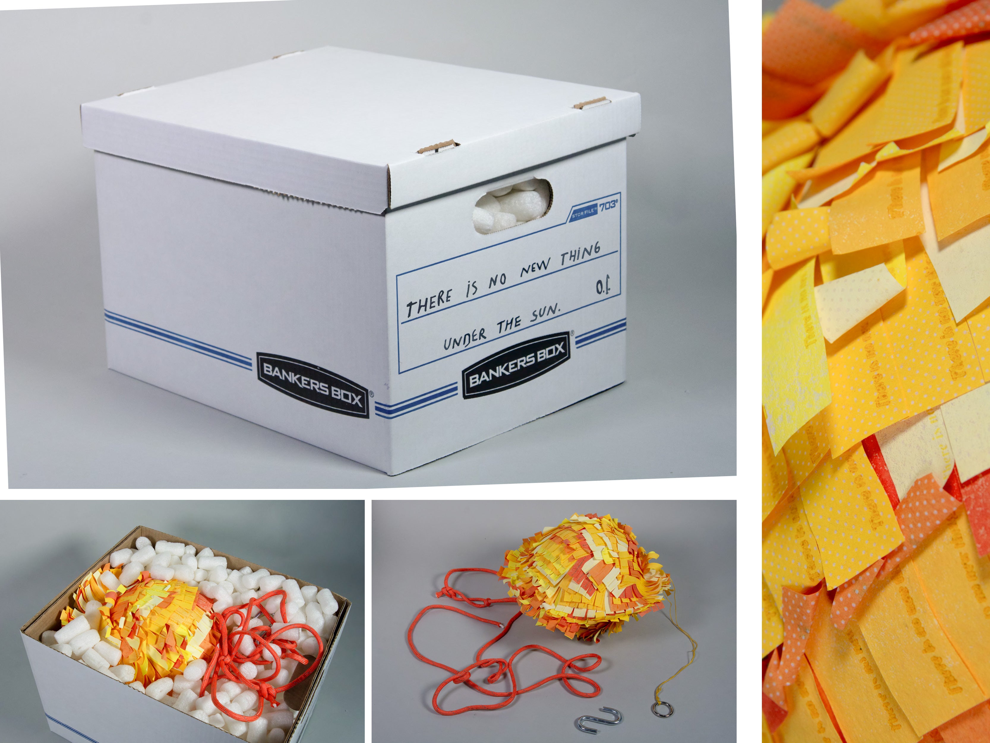 A white cardboard storage box with handwritten text on the side reading ‘THERE IS NO NEW THING UNDER THE SUN’ sits against a gray background. Inside the box are white packing peanuts, a sun-shaped piñata