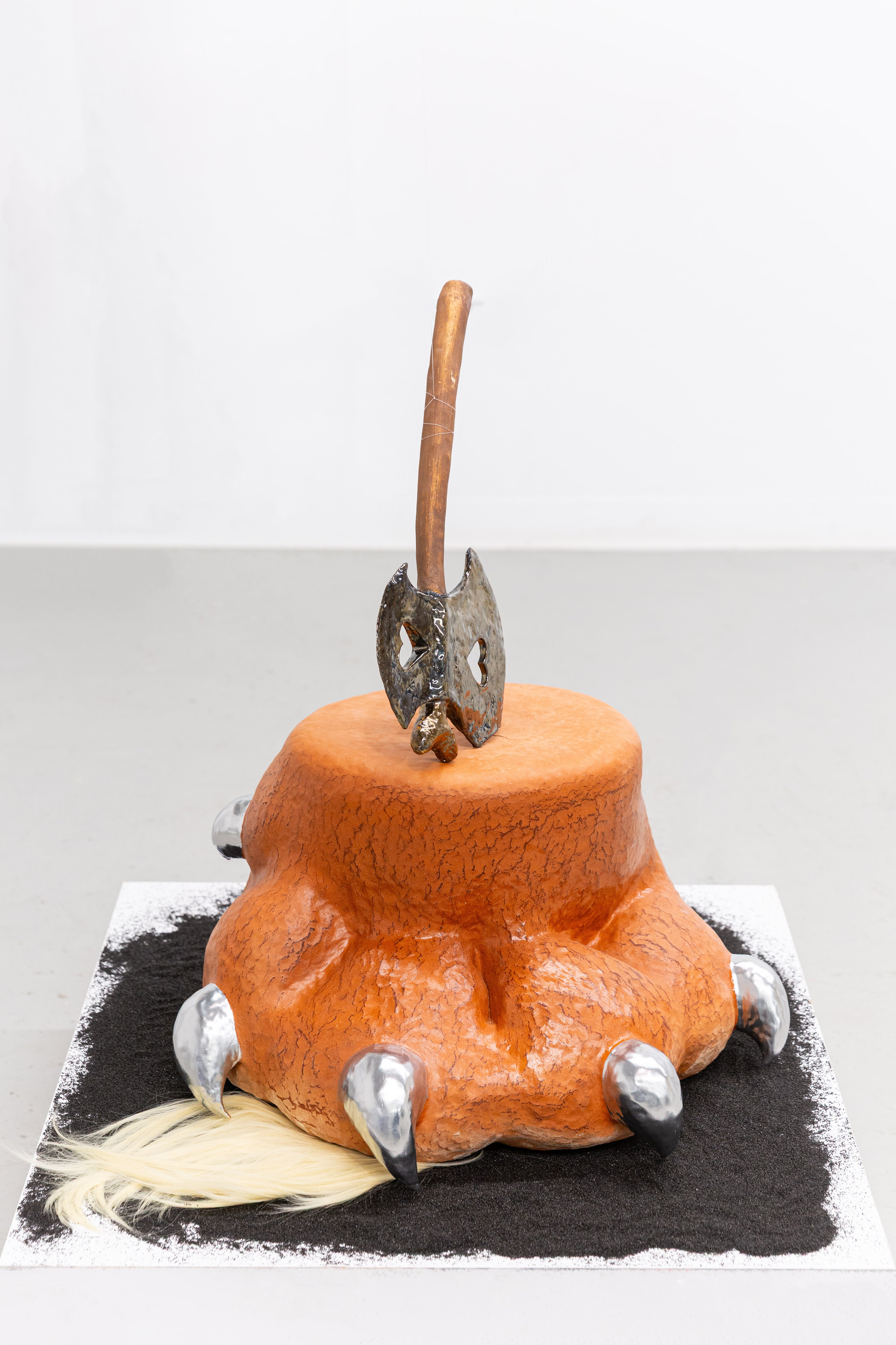 Claw-shaped stump sculpture with metallic glaze and a tuft of fur at the base. Ceramic form sits between plant and creature, combining soft and sharp elements to create tension and ambiguity.