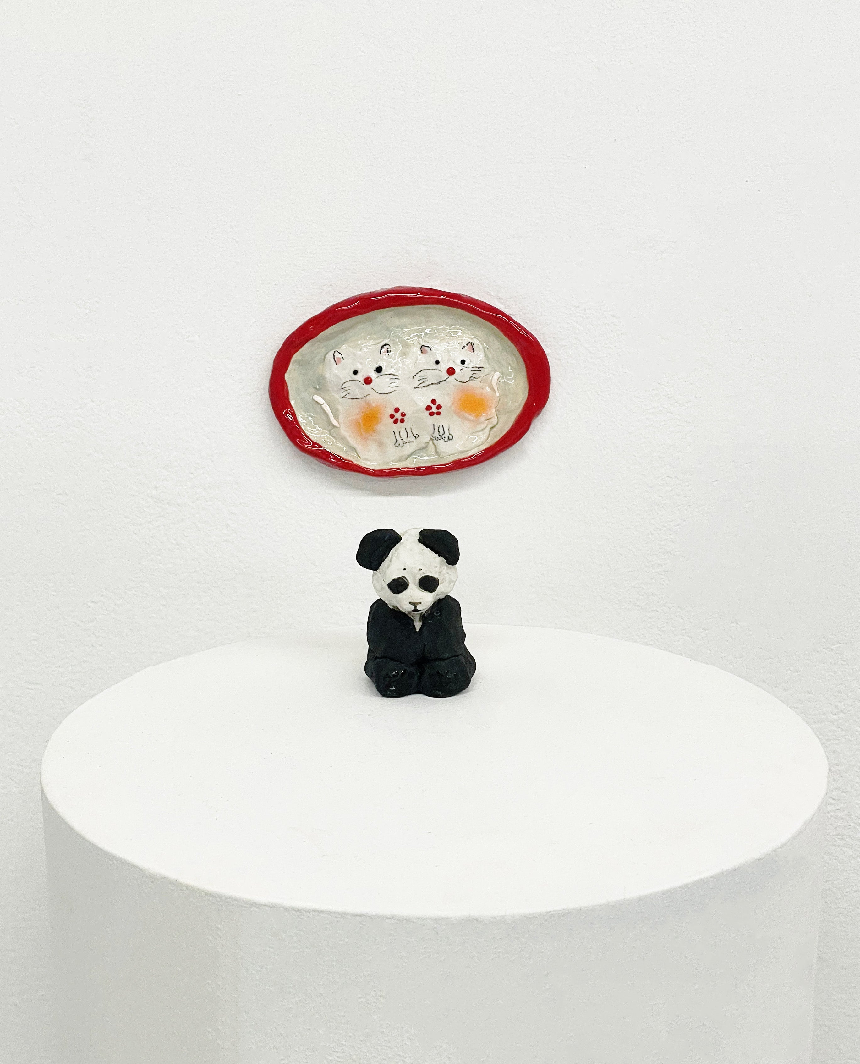 Small ceramic figure combining a panda and cat with fuzzy texture. Playful hybrid form referencing 1980s Chinese imagery and nostalgia.