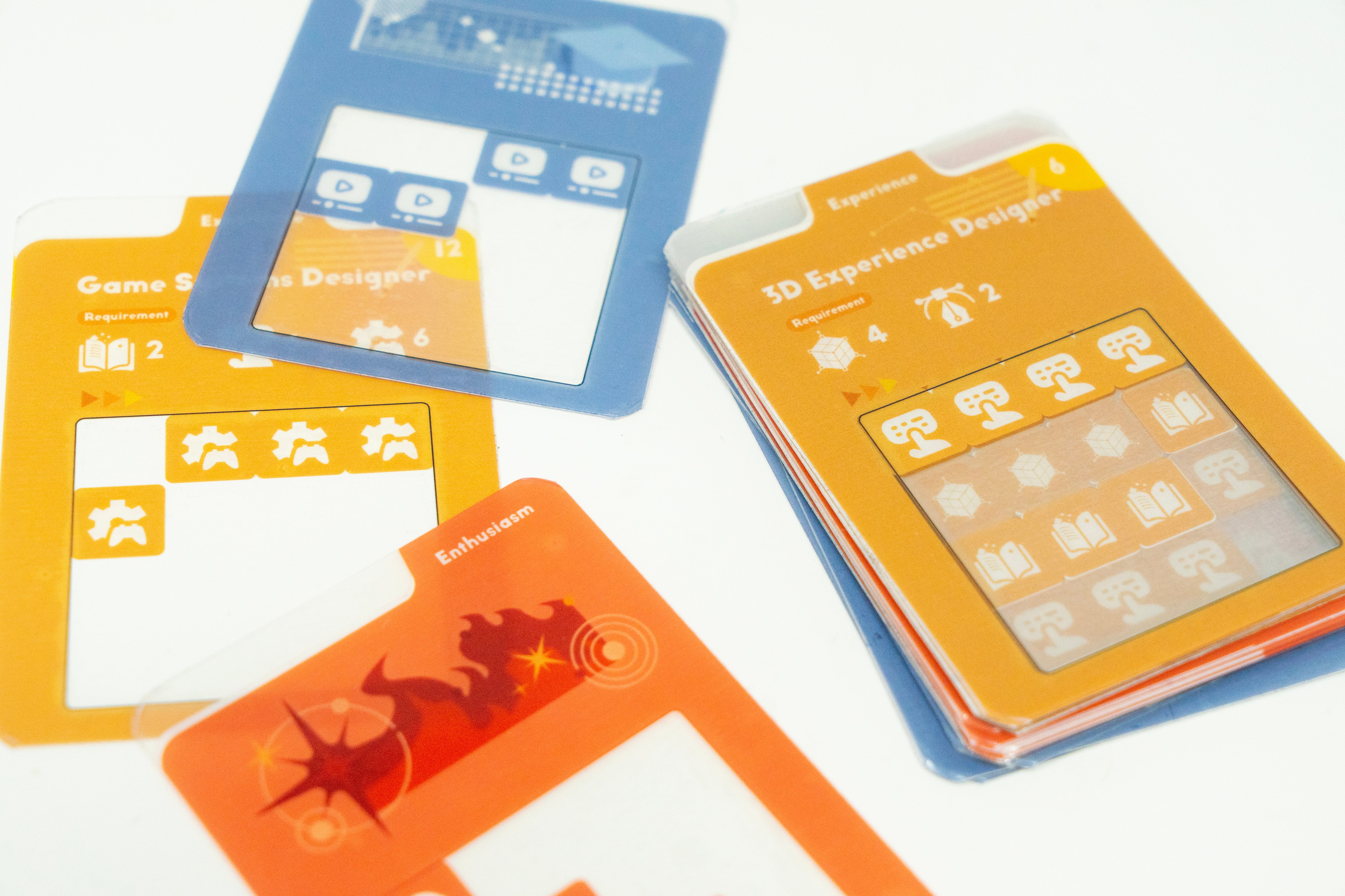Transparent overlay cards placed on colorful job-description cards in a tabletop board game prototype about resume-building, persuasive communication, and role-play.